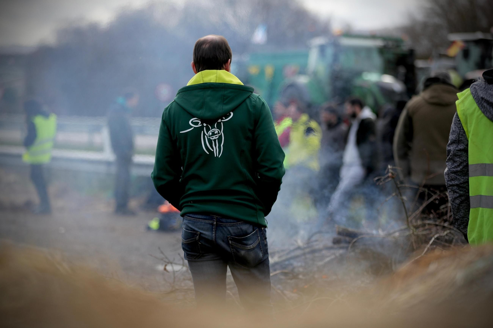 Los manifestantes entre barricadas de paja y pallets ardiendo, mucho frío y parapetados por sus tractores.