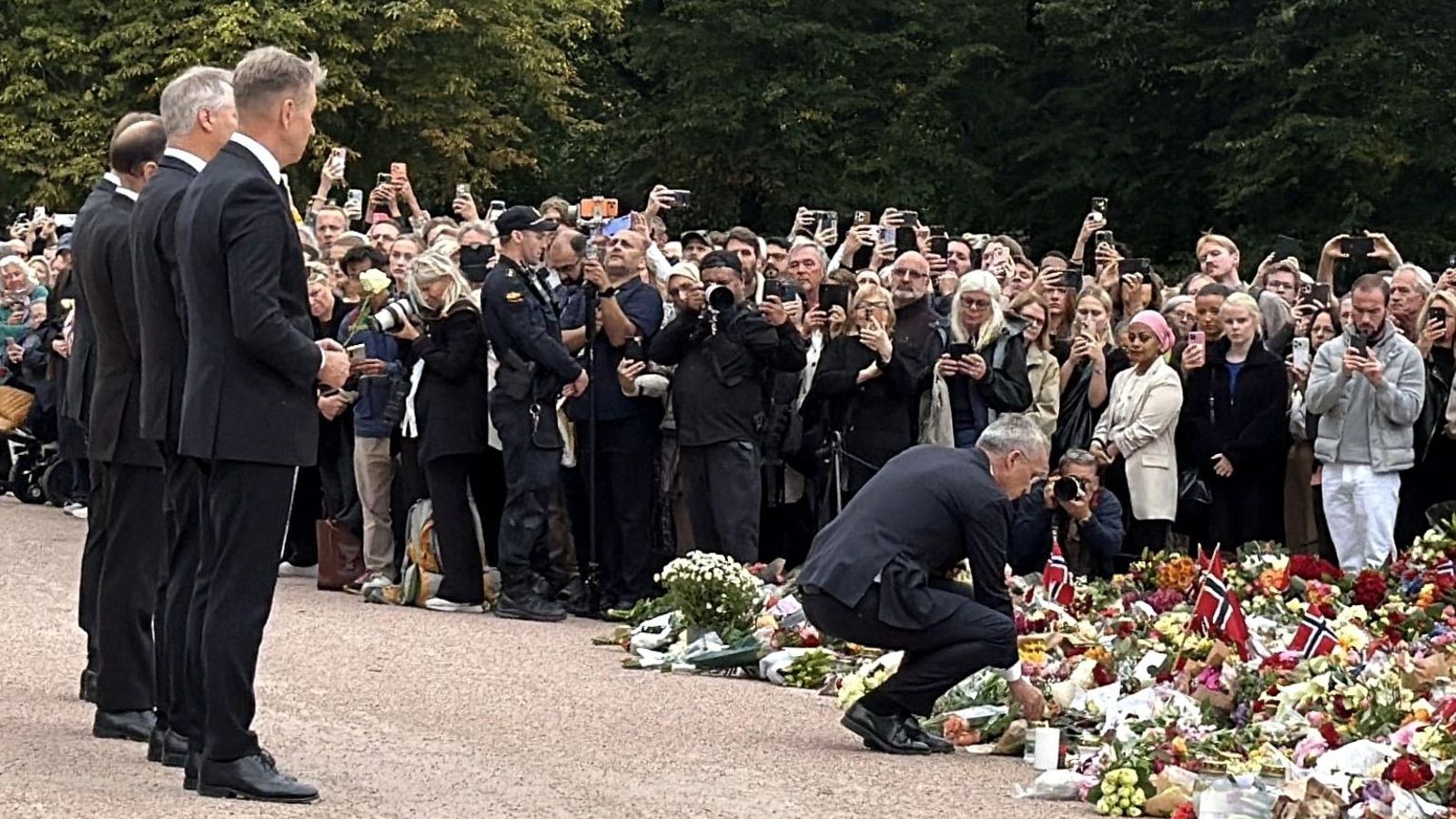 El primer ministro noruego, Jonas Gahr Store, suma una flor a las depositadas por la ciudadanía en honor del rey Harald V frente al Palacio Real de Oslo