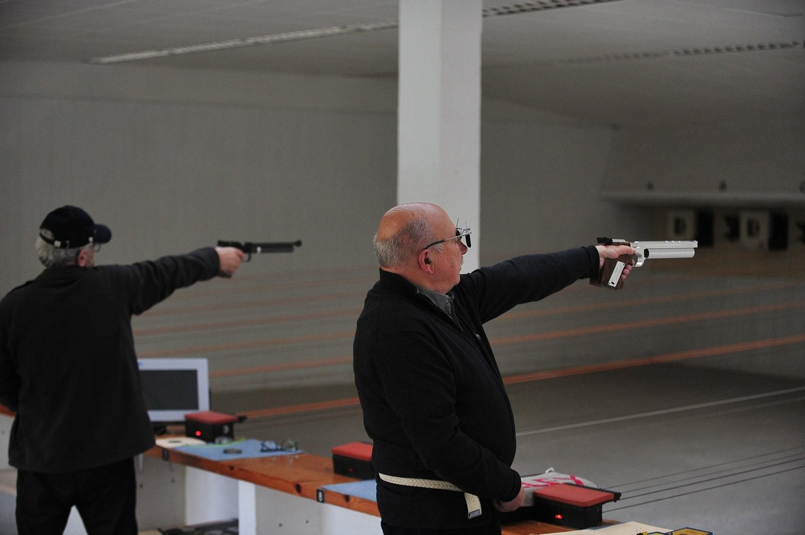 Participantes elevando la pistola.