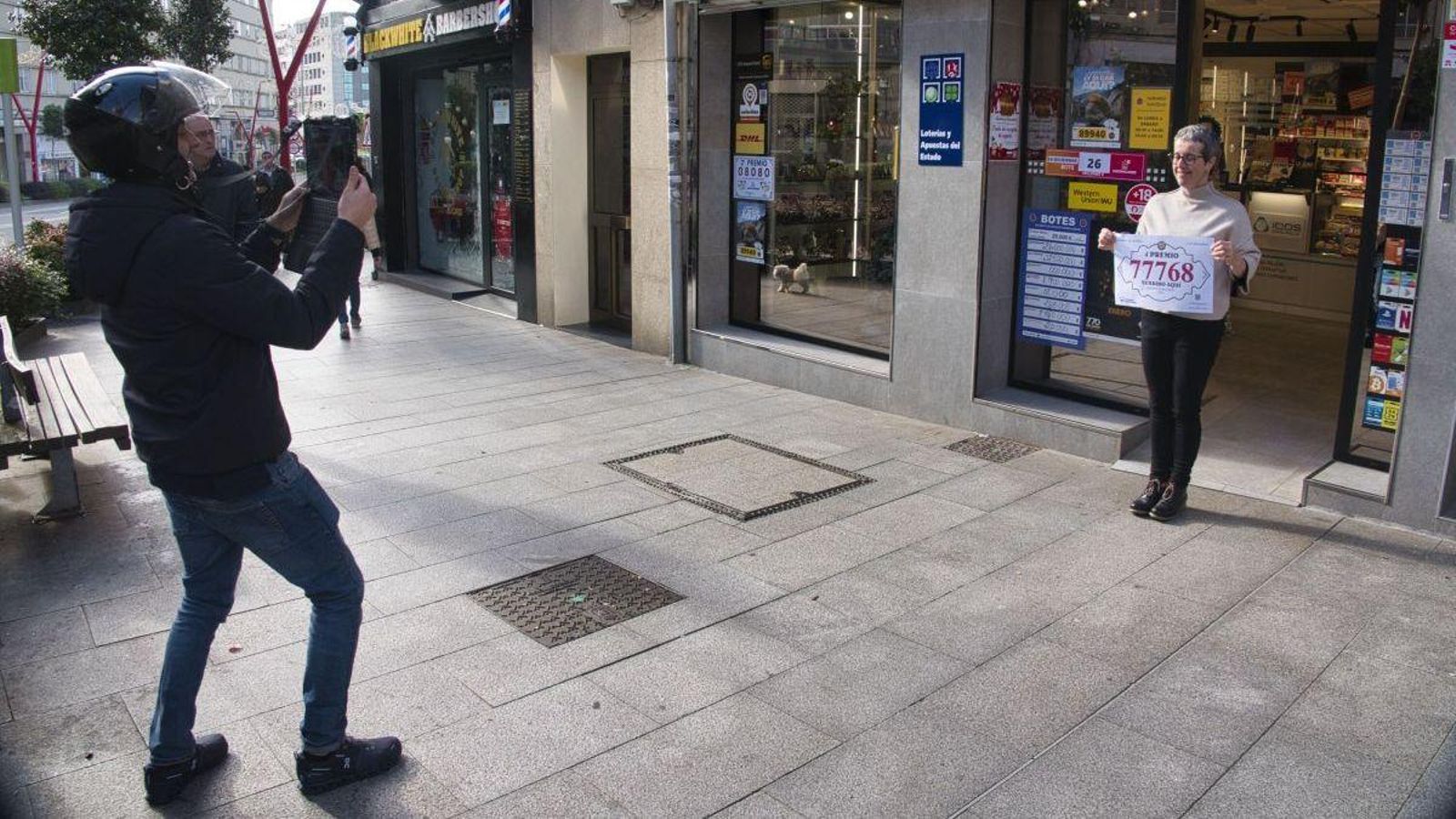 Tras entregar el cartel, el empleado de Loterías inmortaliza el momento.