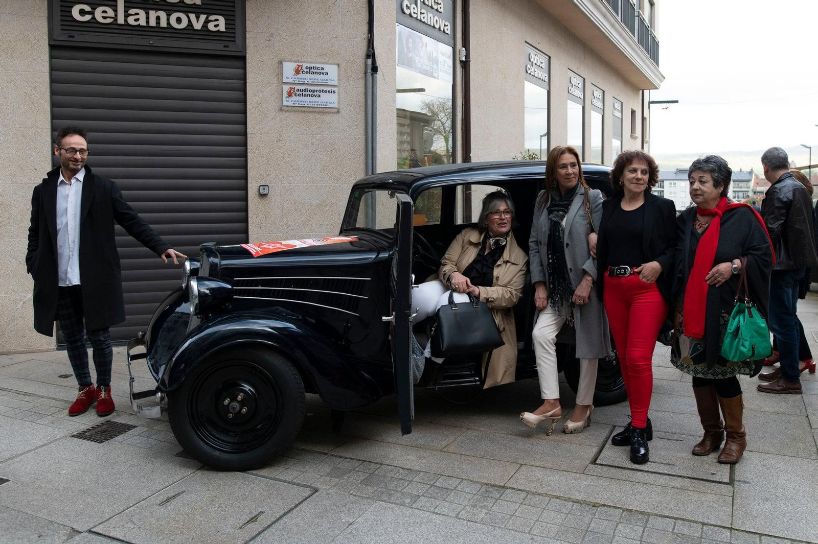 Grupo de gente posando con el coche de patrocinio.