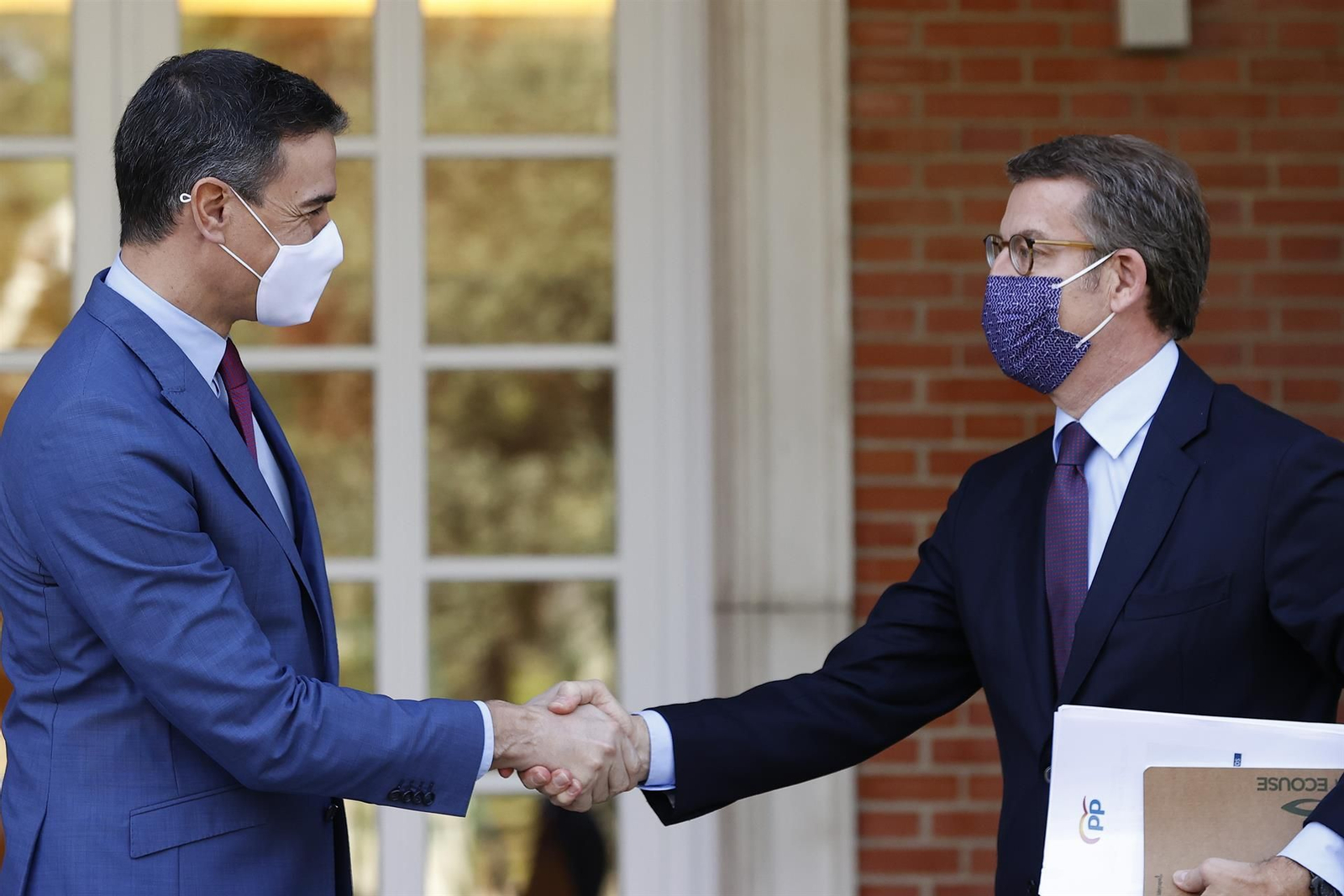 Sánchez y Feijóo se dan la mano a la llegada del líder popular a la Moncloa. // EFE