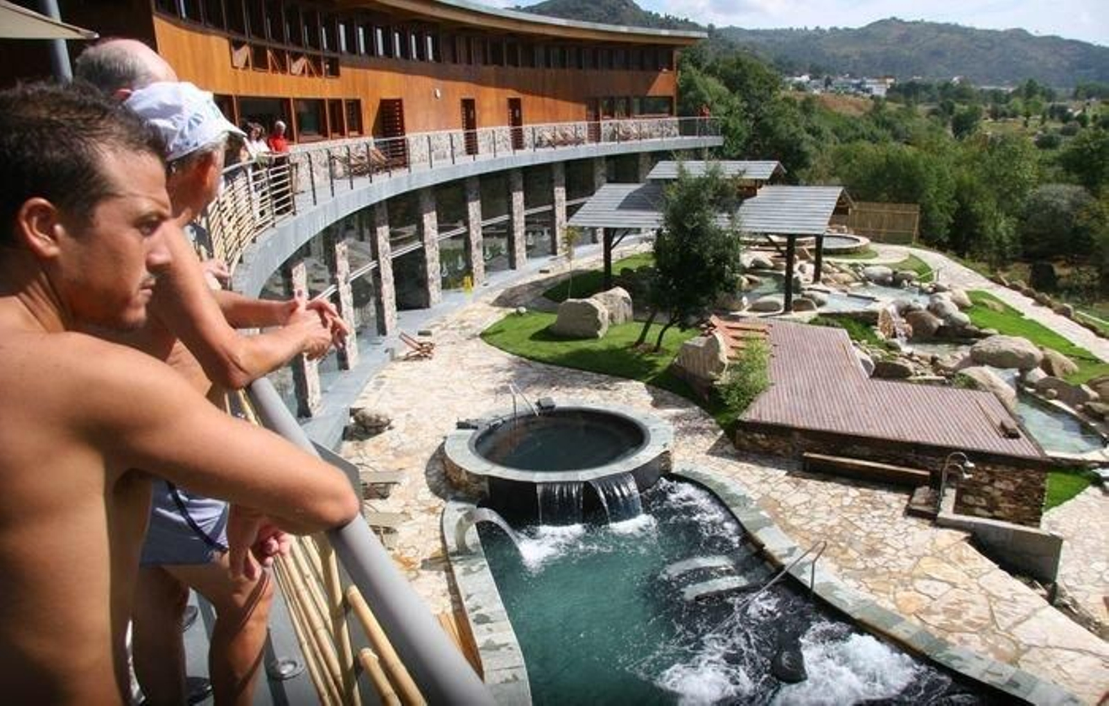 Tres personas observando las termas ourensanas.