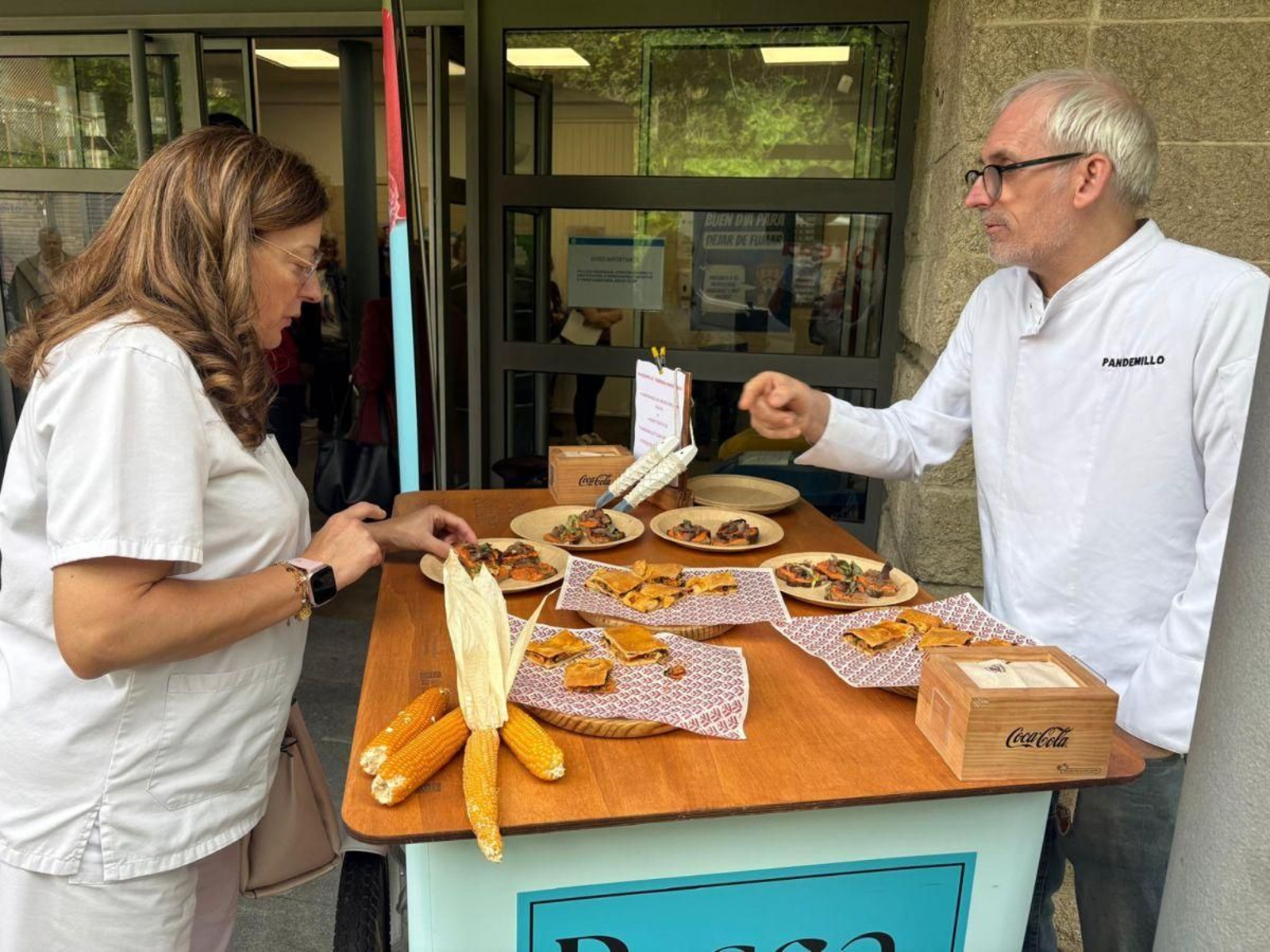 Una sanitaria interesándose por la oferta gastronómica con pescado.