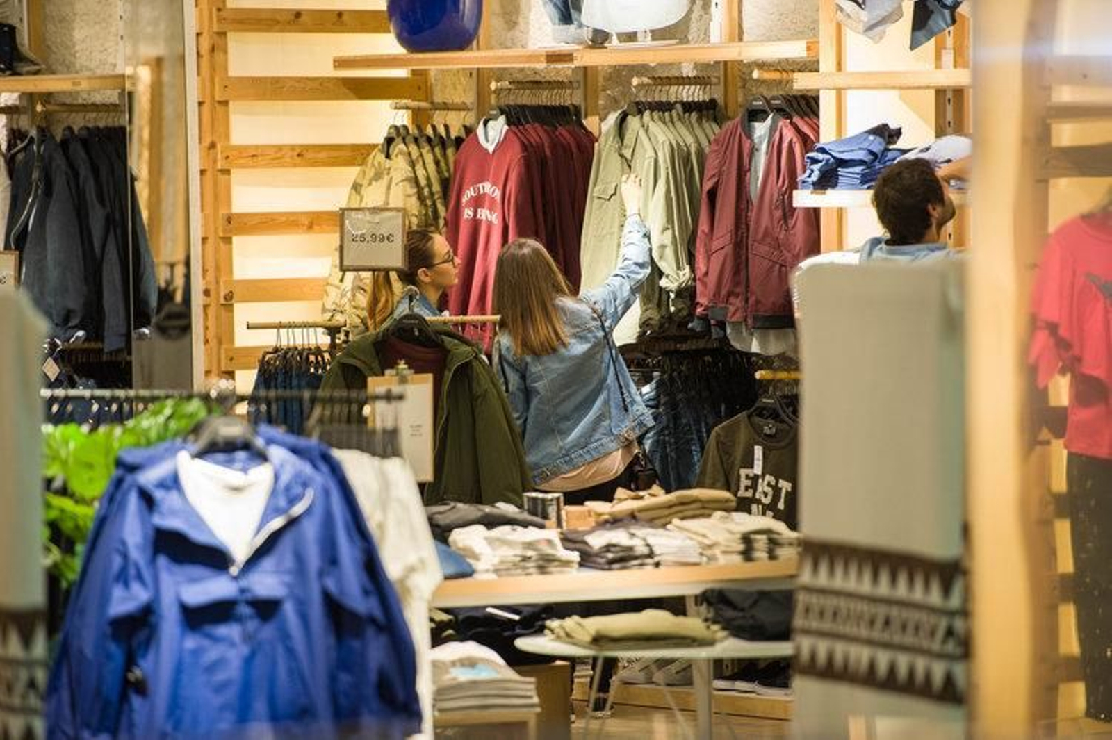 Dos chicas examinan prendas en una tienda del centro.
