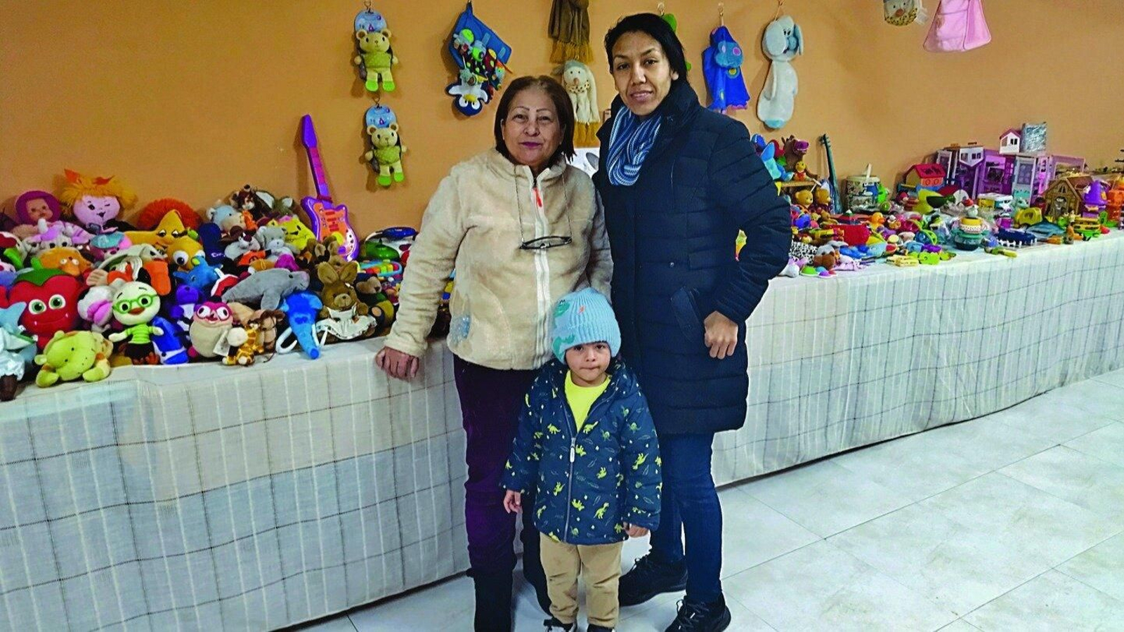 Las voluntarias Argenis Parra y Marcela Sánchez, ante un expositor de juguetes.