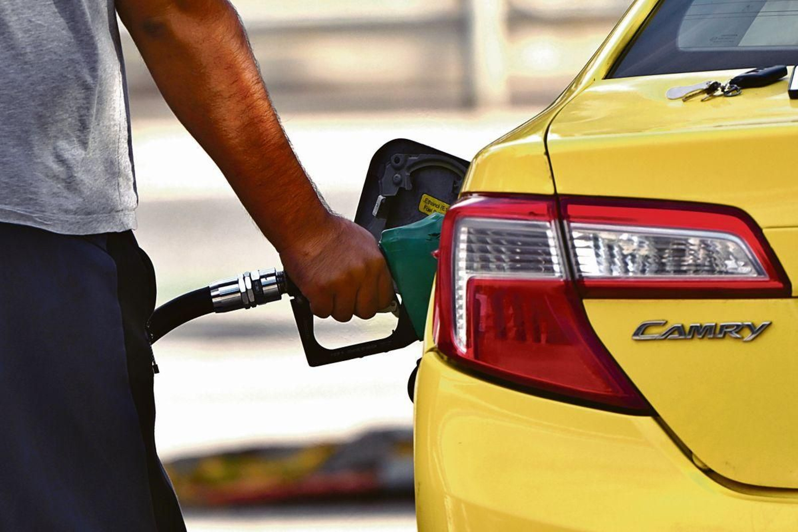 Una persona repostando combustible en su vehículo.