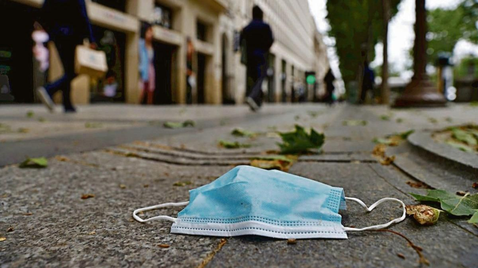 Una mascarilla sanitaria tirada en el suelo.