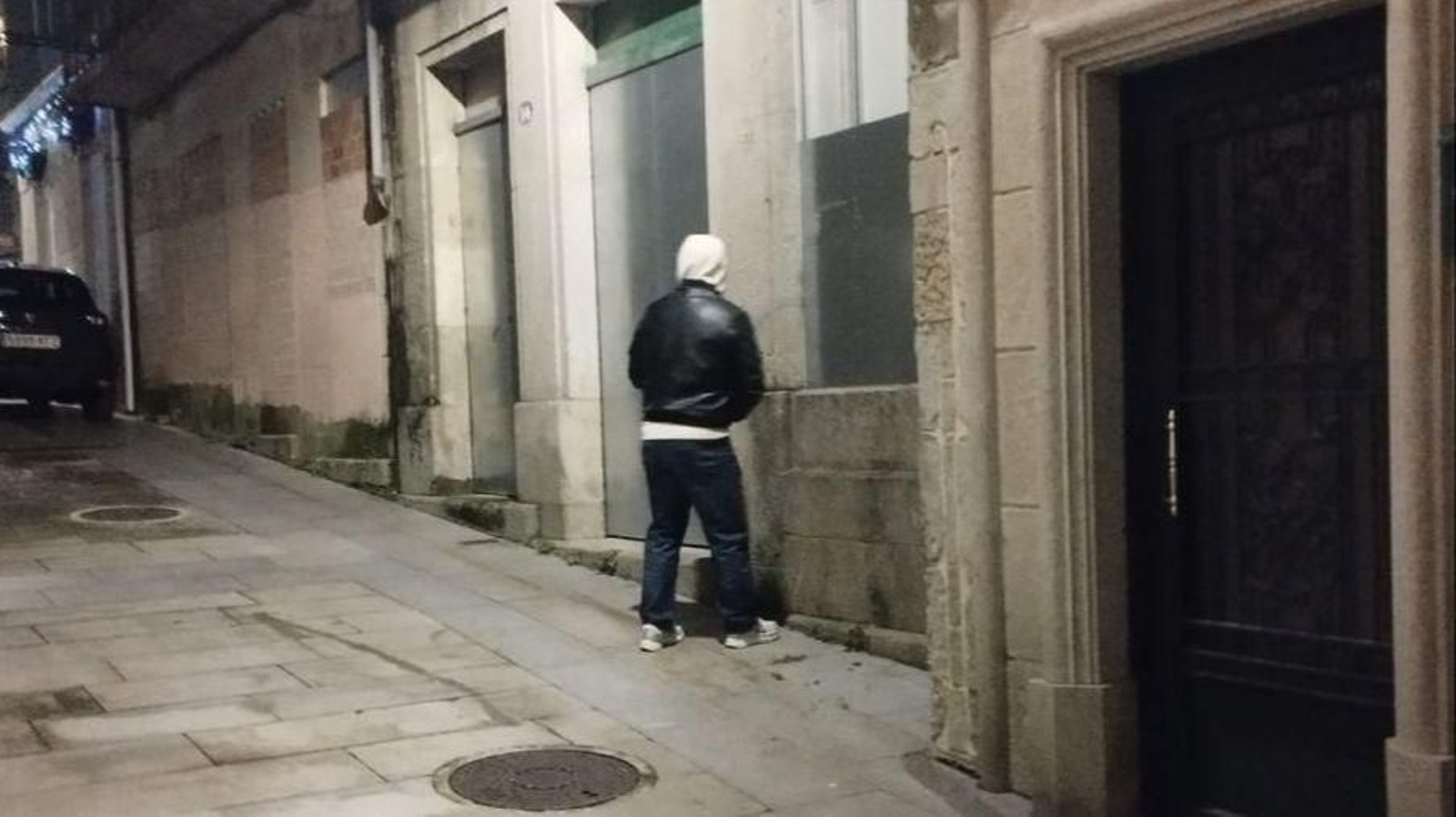 Una personas orinando en la vía pública durante las celebraciones de Navidad en el casco vello.