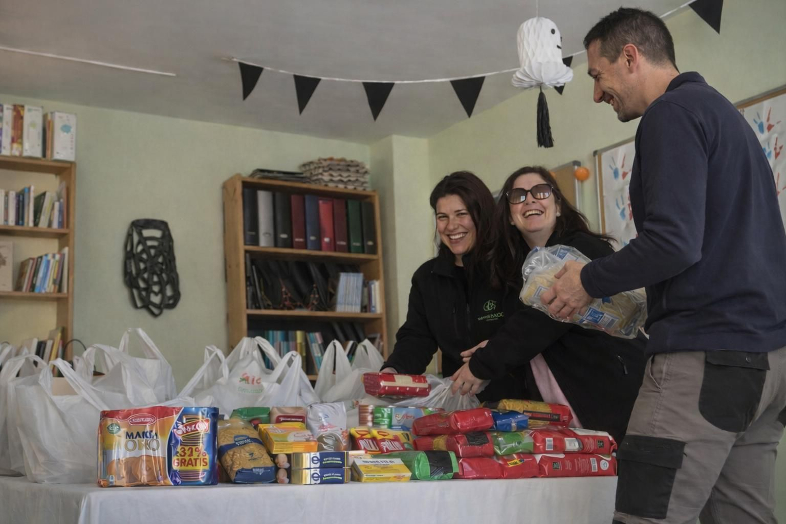 Isabel Rodríguez, secretaria de Medrando, y Cristina Rivera, tesosera, con un voluntario en una jornada de recogida.