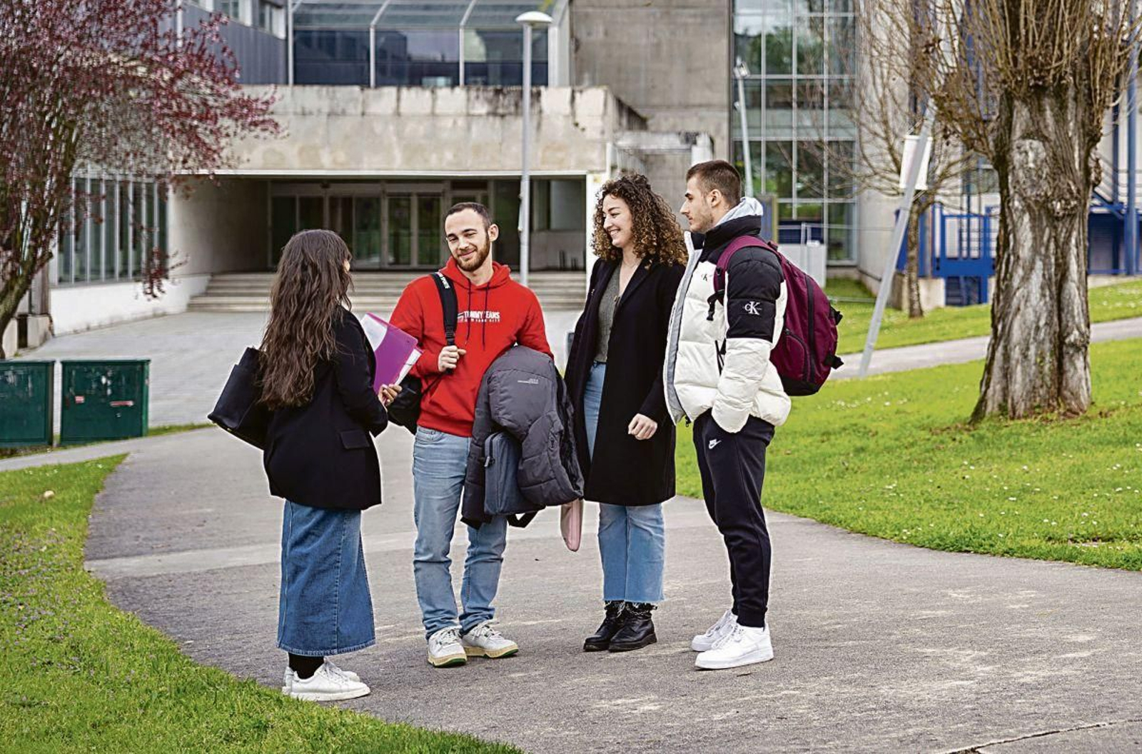 Cuatro estudiantes en el campus de la Universidad de Vigo.