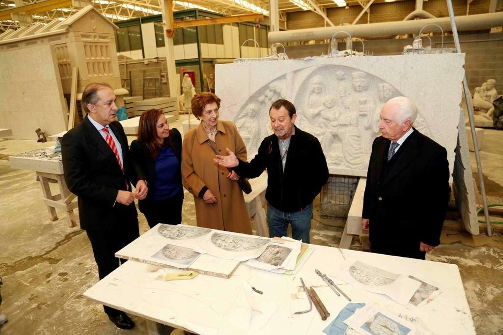El vicepresidente de la Diputación, Chema Figueroa y el párroco de la Concatedral (a la derecha) escuchan las explicaciones de la Escuela de Cantería de Poio. Detrás, la réplica del tímpano.