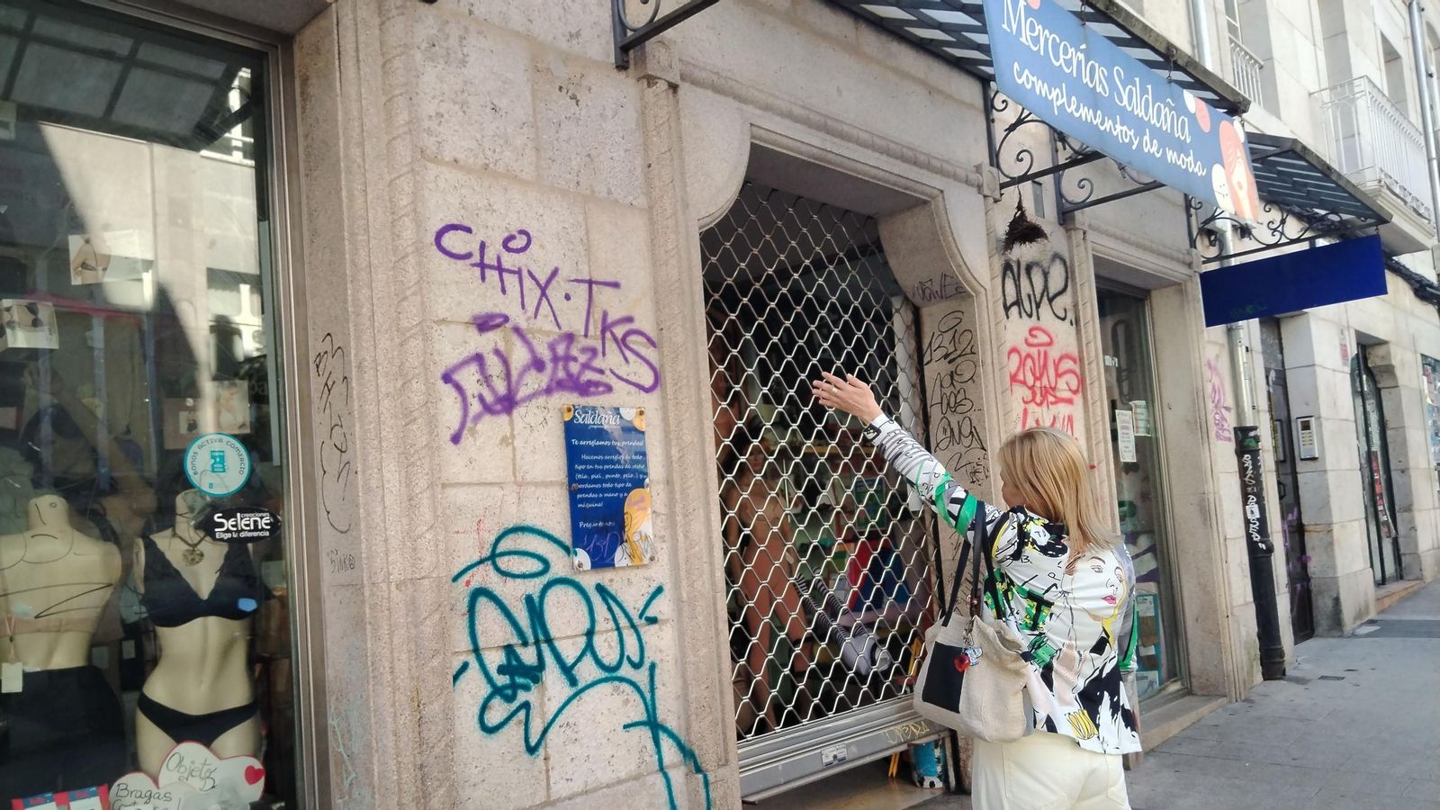 Patricia señala la fachada vandalizada de su negocio.