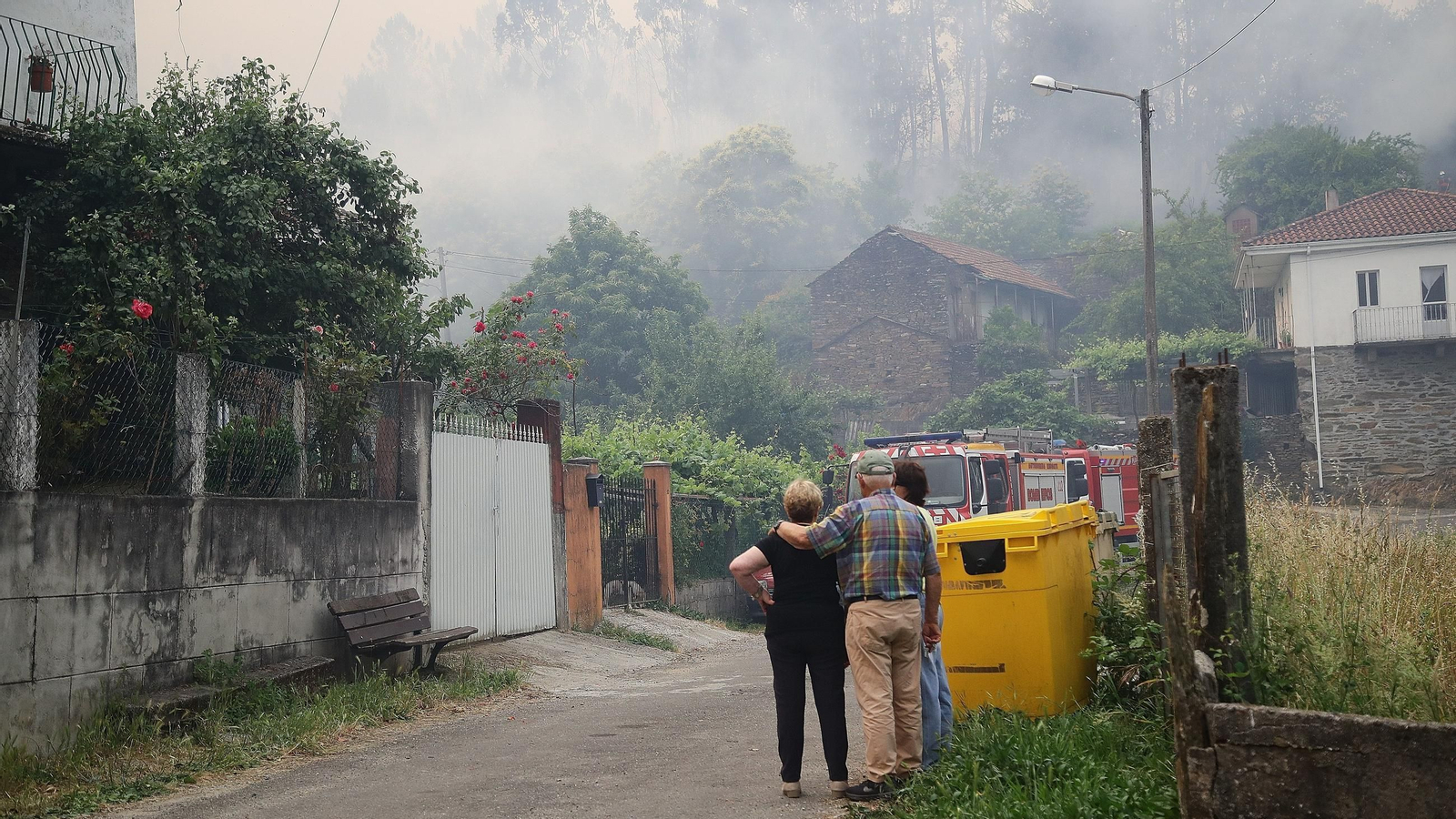 Los vecinos de Vecoña (Boborás) contemplan el avance del incendio, próximo a las casas.