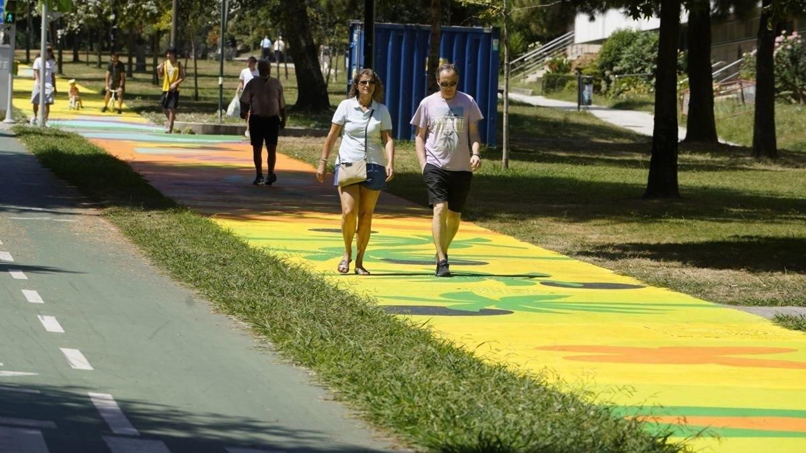 Varias personas paseando sobre el mural de Vanesa Álvarez ya finalizado en Coia.