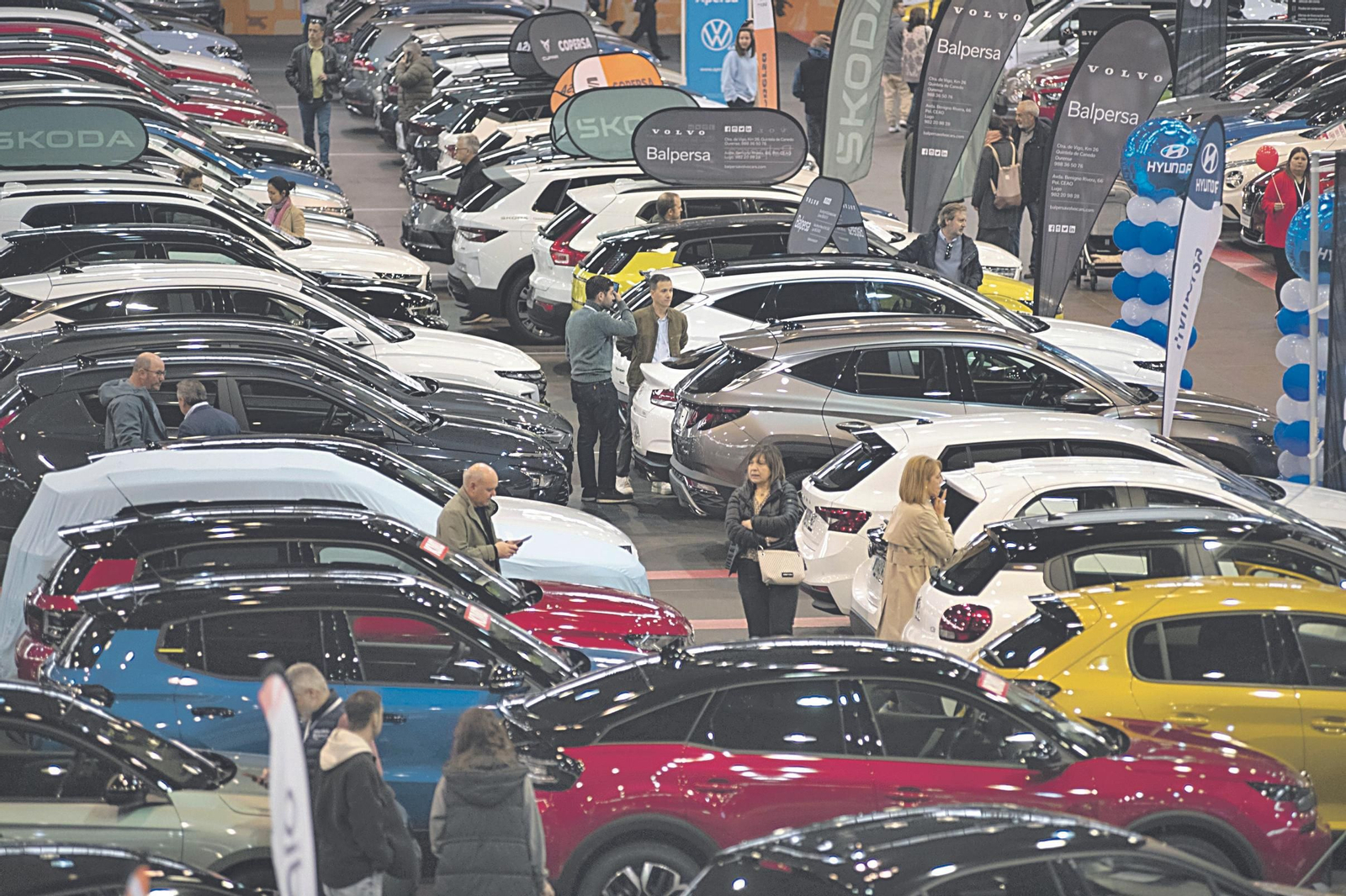 Visitantes del Salón del Automóvil comprueban las ofertas.