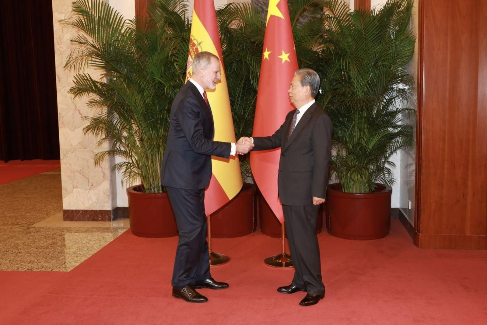 Felipe VI saluda al presidente del Comité de la Asamblea Popular China.