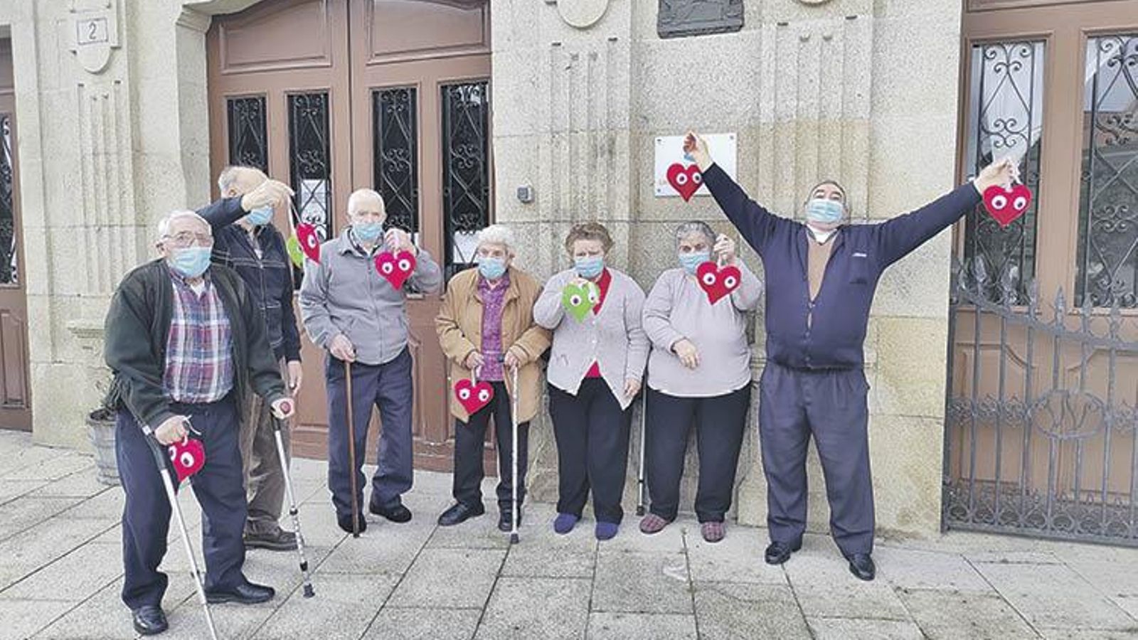 Los mayores posan con los corazones que realizaron.