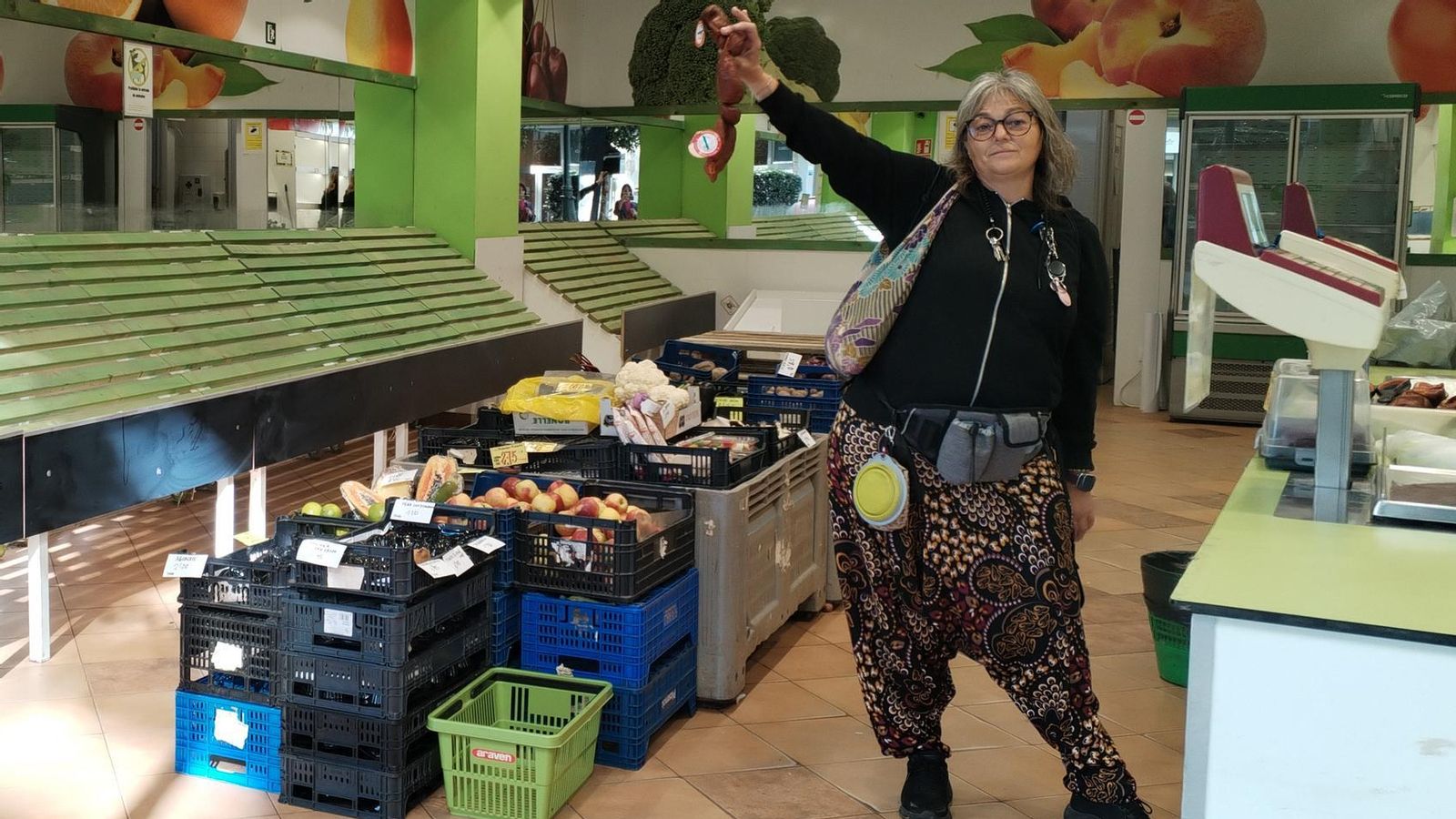 Susana, clienta habitual en Camelias, levanta un rista de chorizos en señal de enfado por el cierre de la frutería.