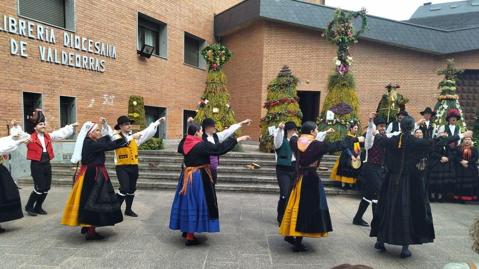 Integrantes de Cantigas e Agarimos danzan ante los “maios” de O Barco.
