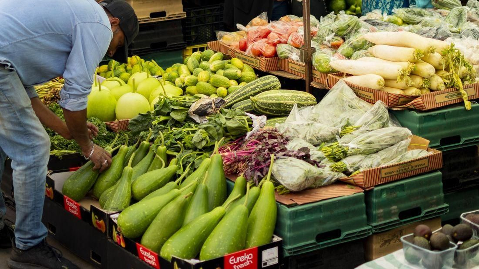 Un tendero prepara verduras en un mercado. (Foto: Unsplash)