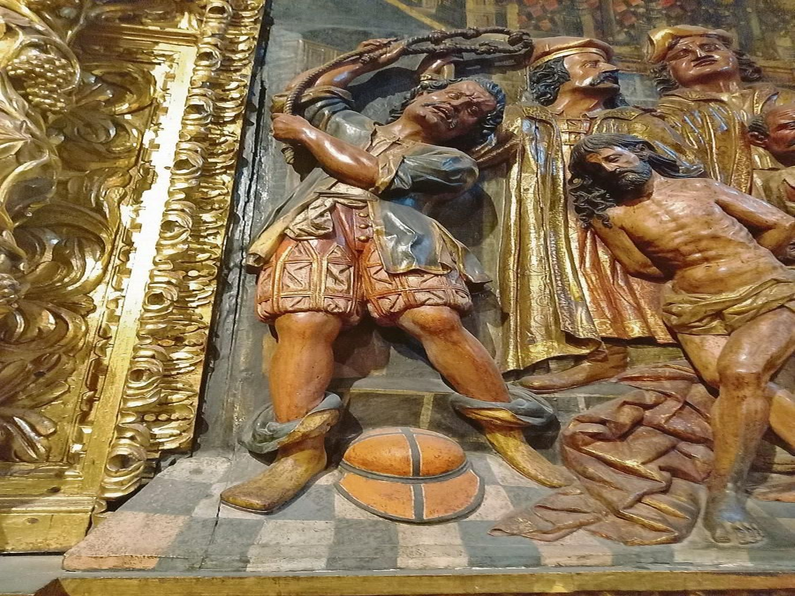 "Gorra de baseball", No es una gorra de béisbol, es el casco del soldado (tipo “lobster tailed”, s. XVII) que realiza la flagelación.