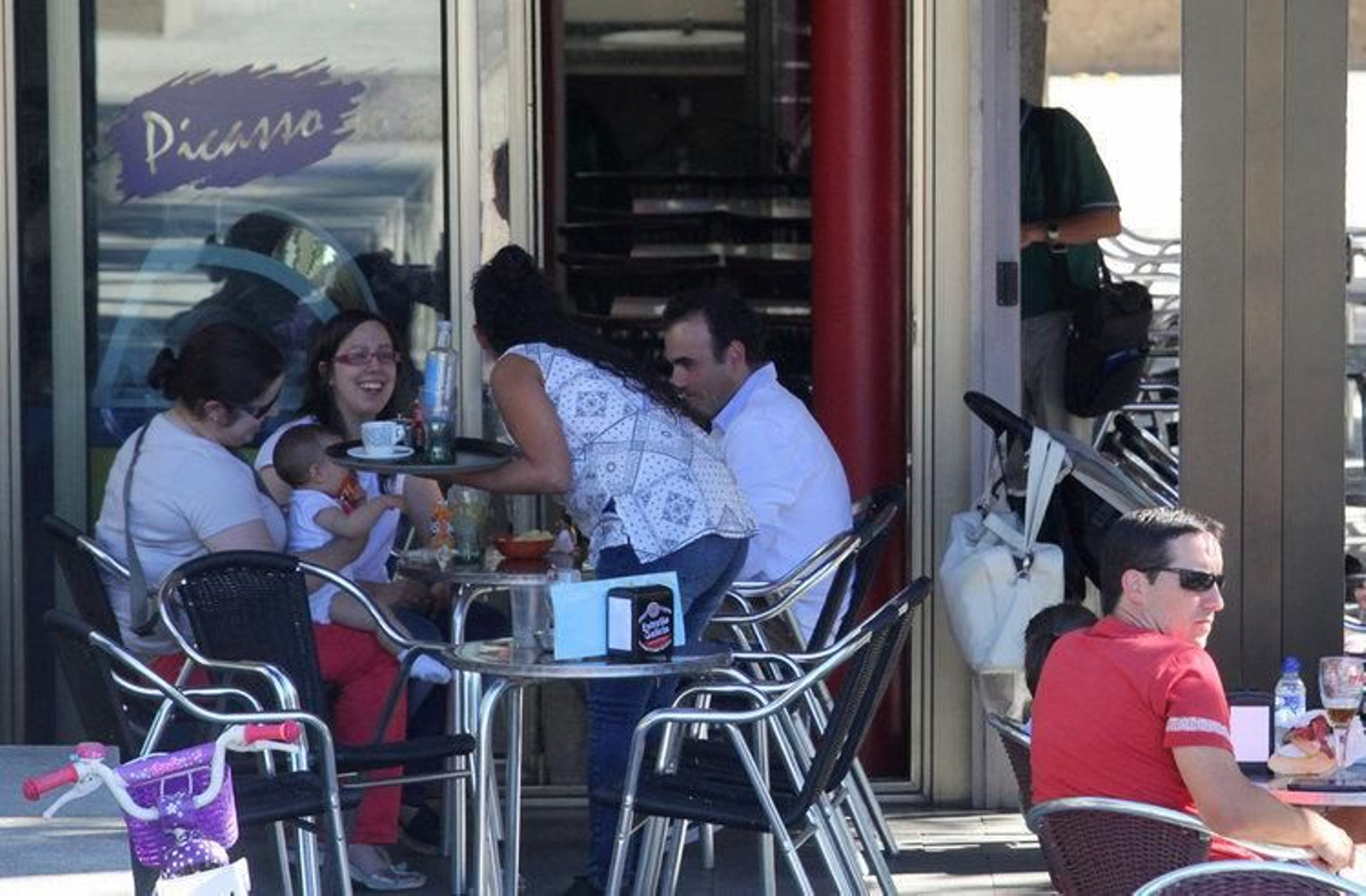 Una joven camarera sirve bebidas en un bar de la ciudad en la tarde de ayer.
