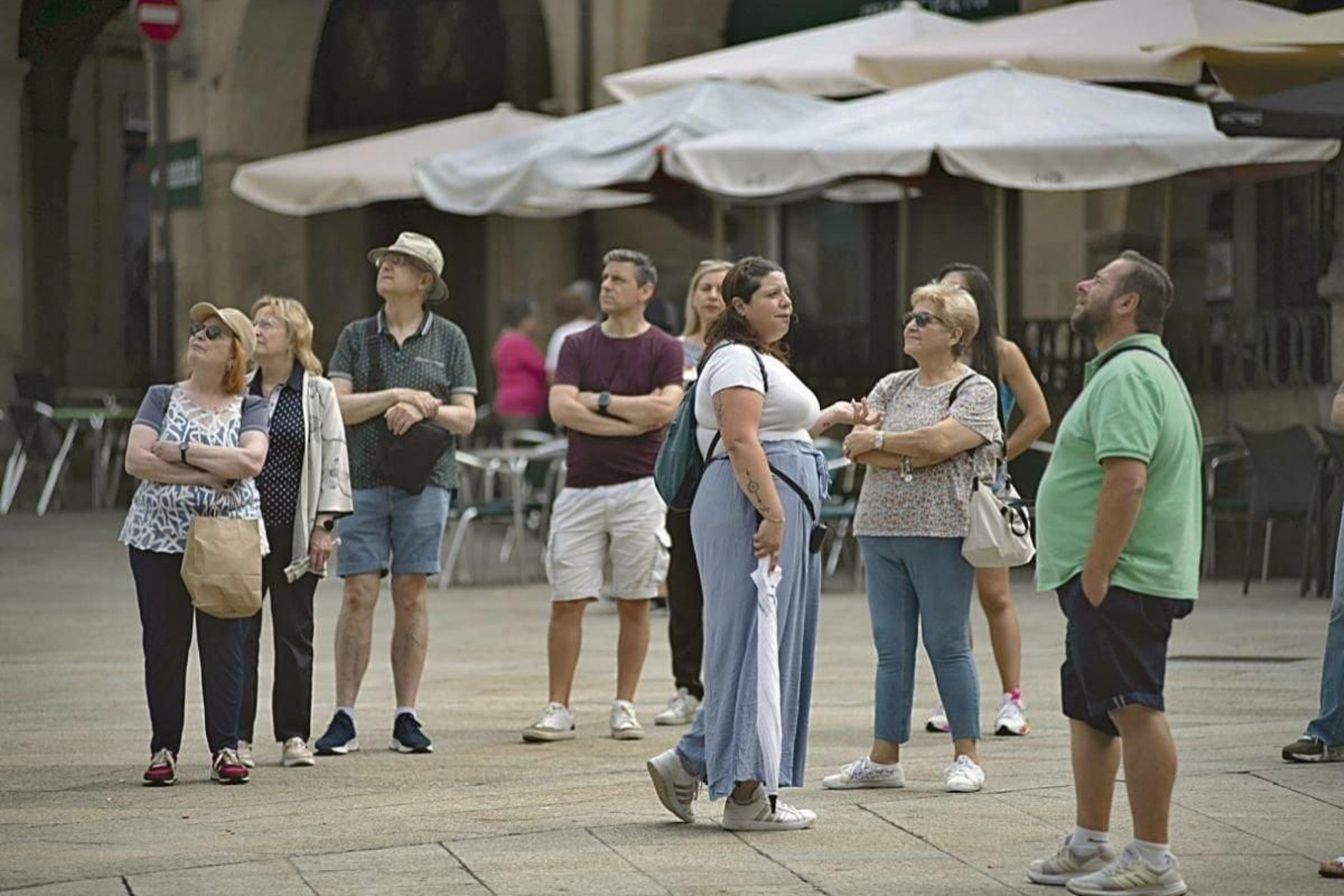Turistas visitan la Praza Maior de la ciudad en una visita guiada.