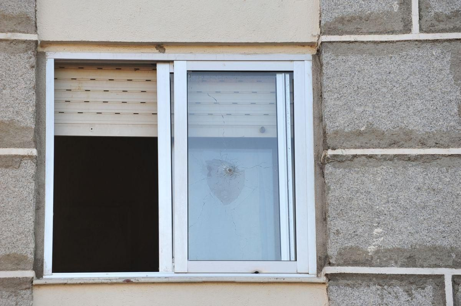 En la ventana de un segundo piso de la urbanización se aprecia un disparo.