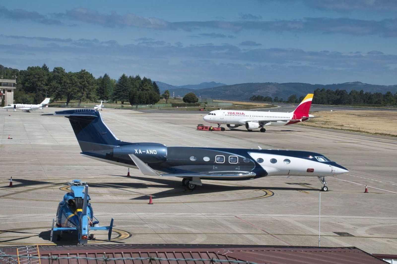 Un avión privado y otro de la compañía Iberia, estacionados en el aeropuerto de Peinador