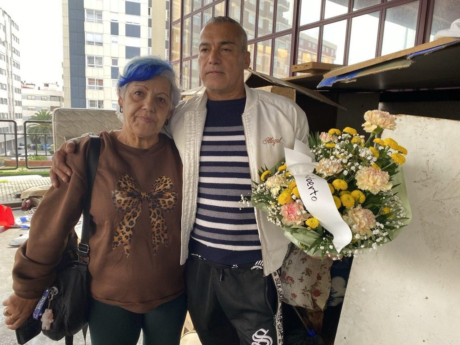La cuñada de Roberto y su sobrino, ayer en la vieja estación, sujetan el  ramo de flores que dejaron Os Ninguéns.