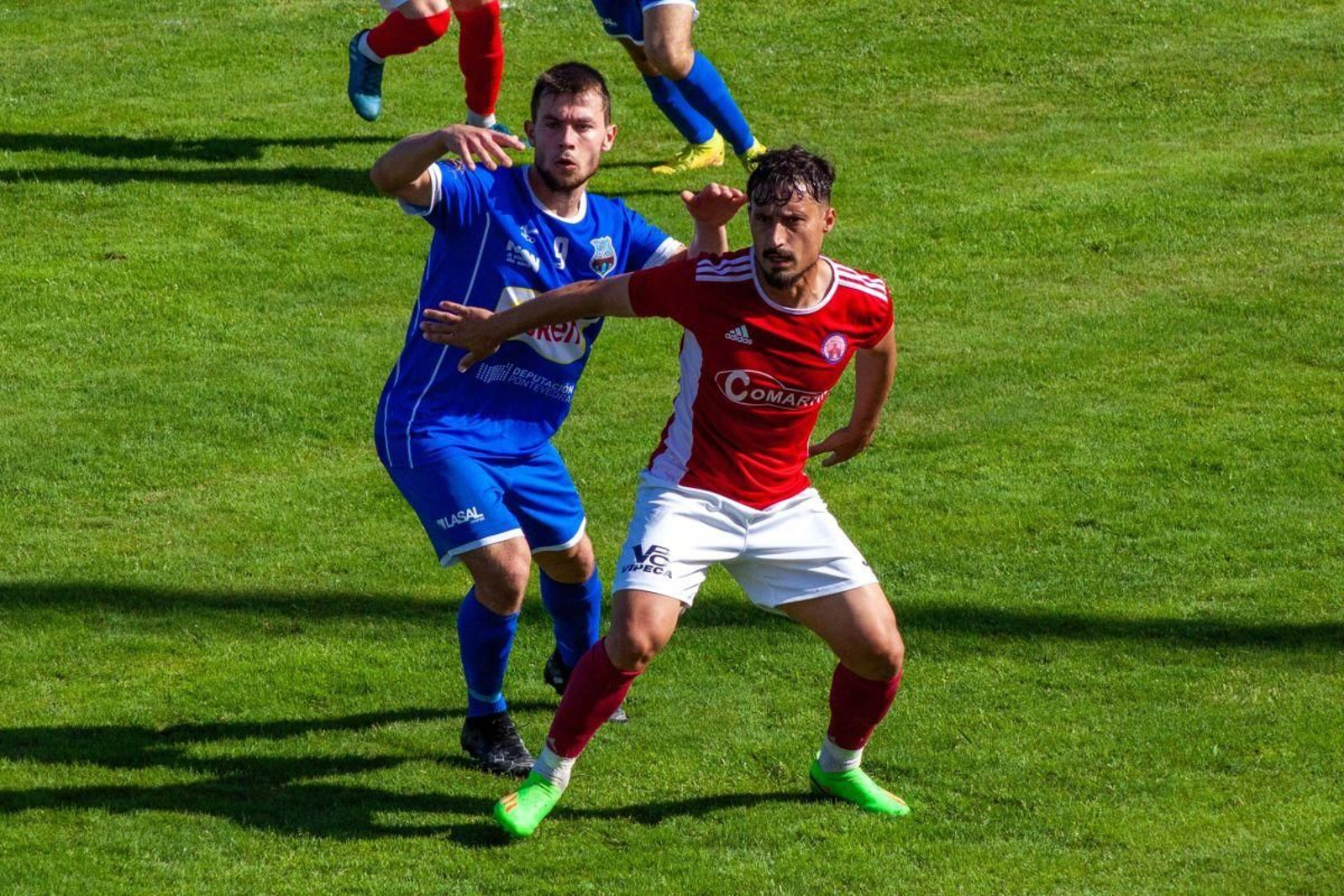 Adrián Mouriño, medipunta del Verín, cubre al delantero del Porriño, Maikel Barbosa, en O Lourambal.