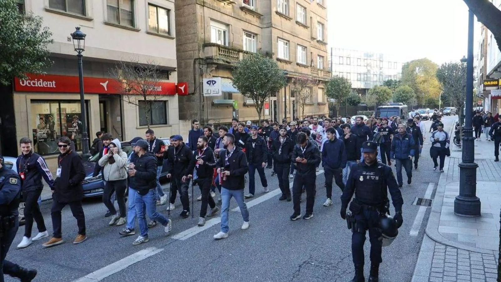 Aficionados del Lyon acuden a Balaídos escoltados por la policía.