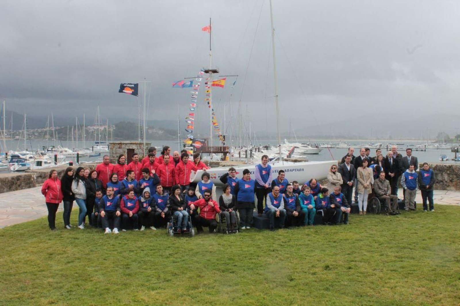 Miembros de la escuela de vela adaptada, monitores y autoridades  junto a uno de los barcos presentados, ayer.