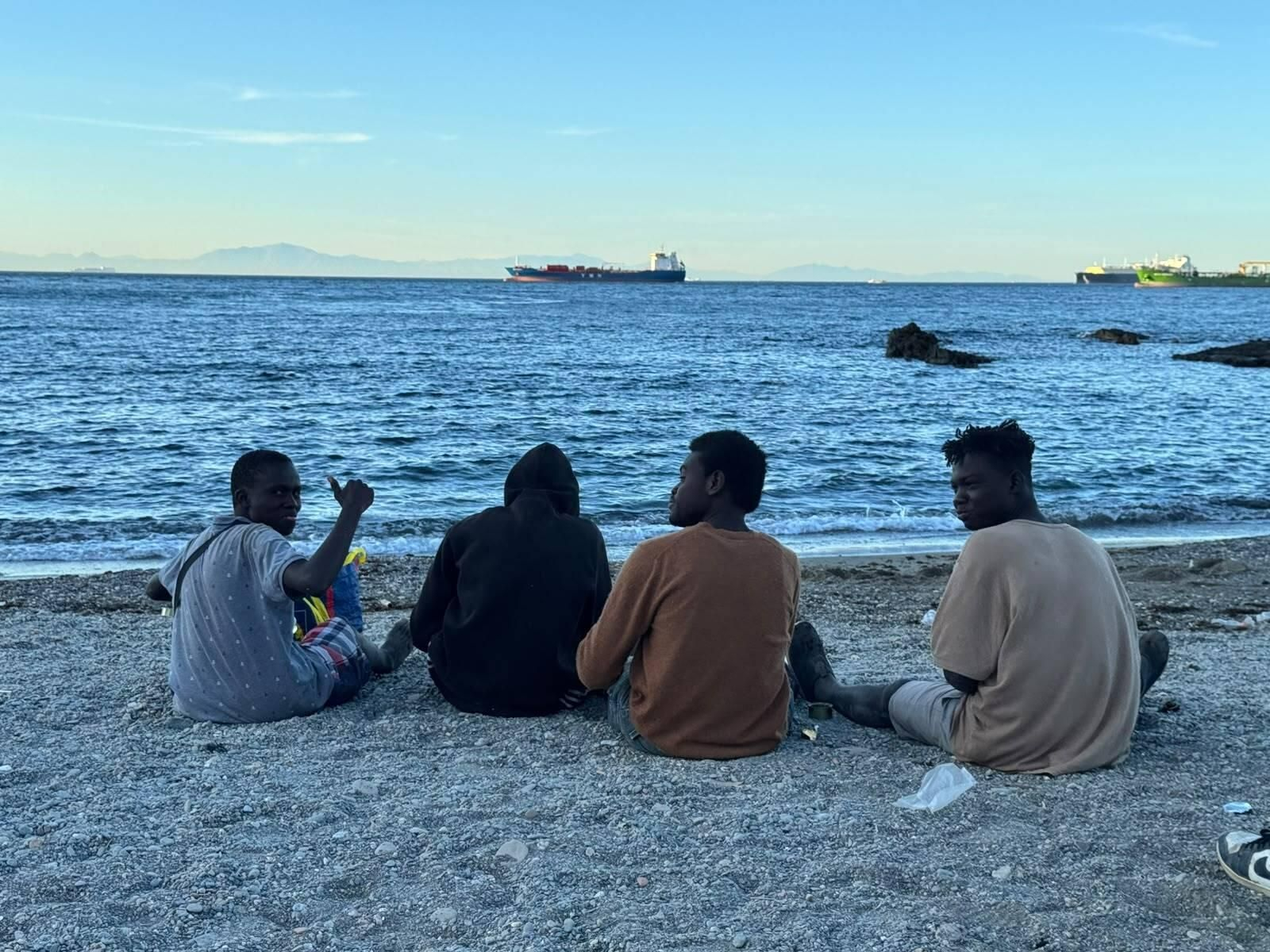 Varios migrantes en la playa del Trampolín