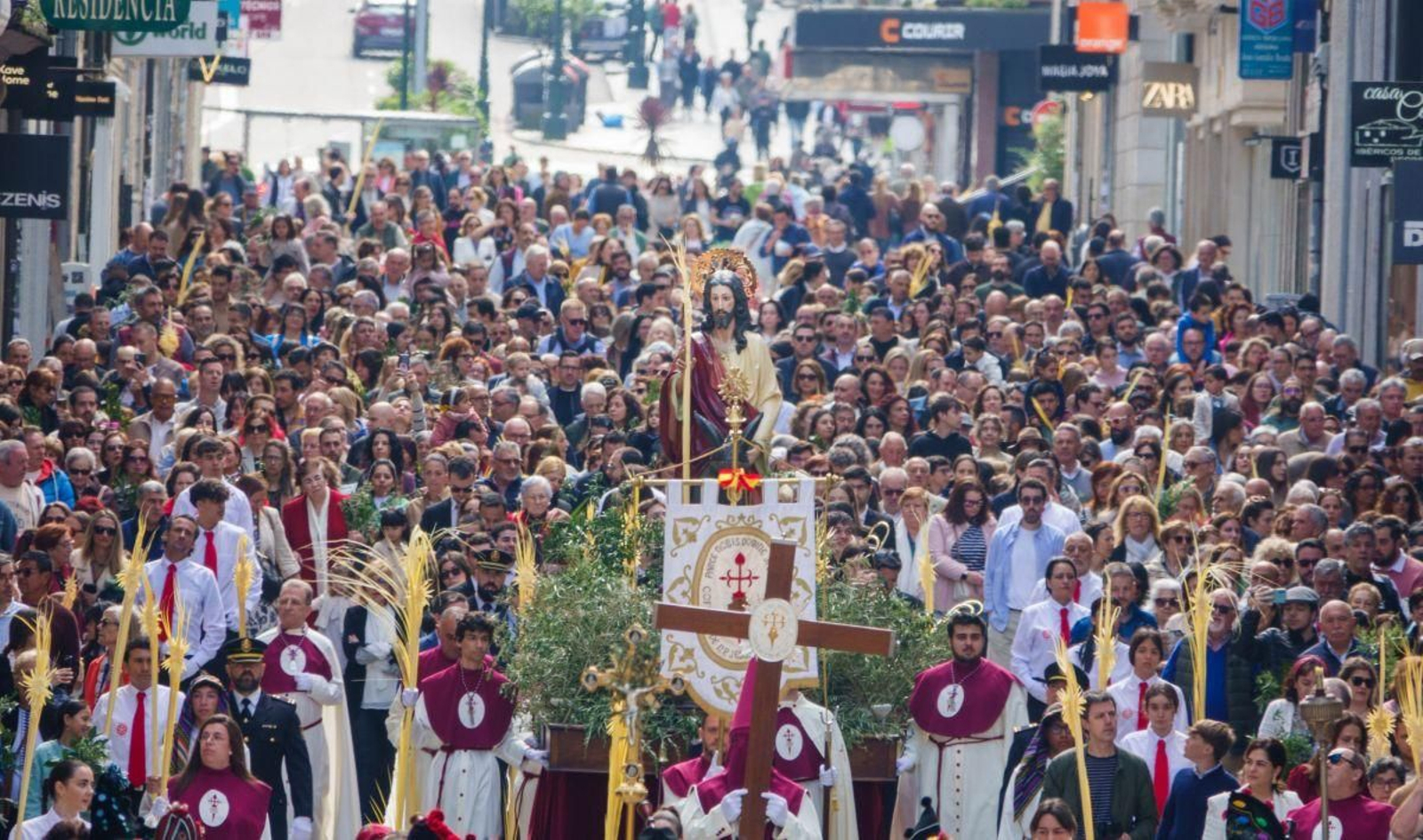La Borriquita, junto con los cofrades y numerosos fieles, en su recorrido por las calles del centro de Vigo.