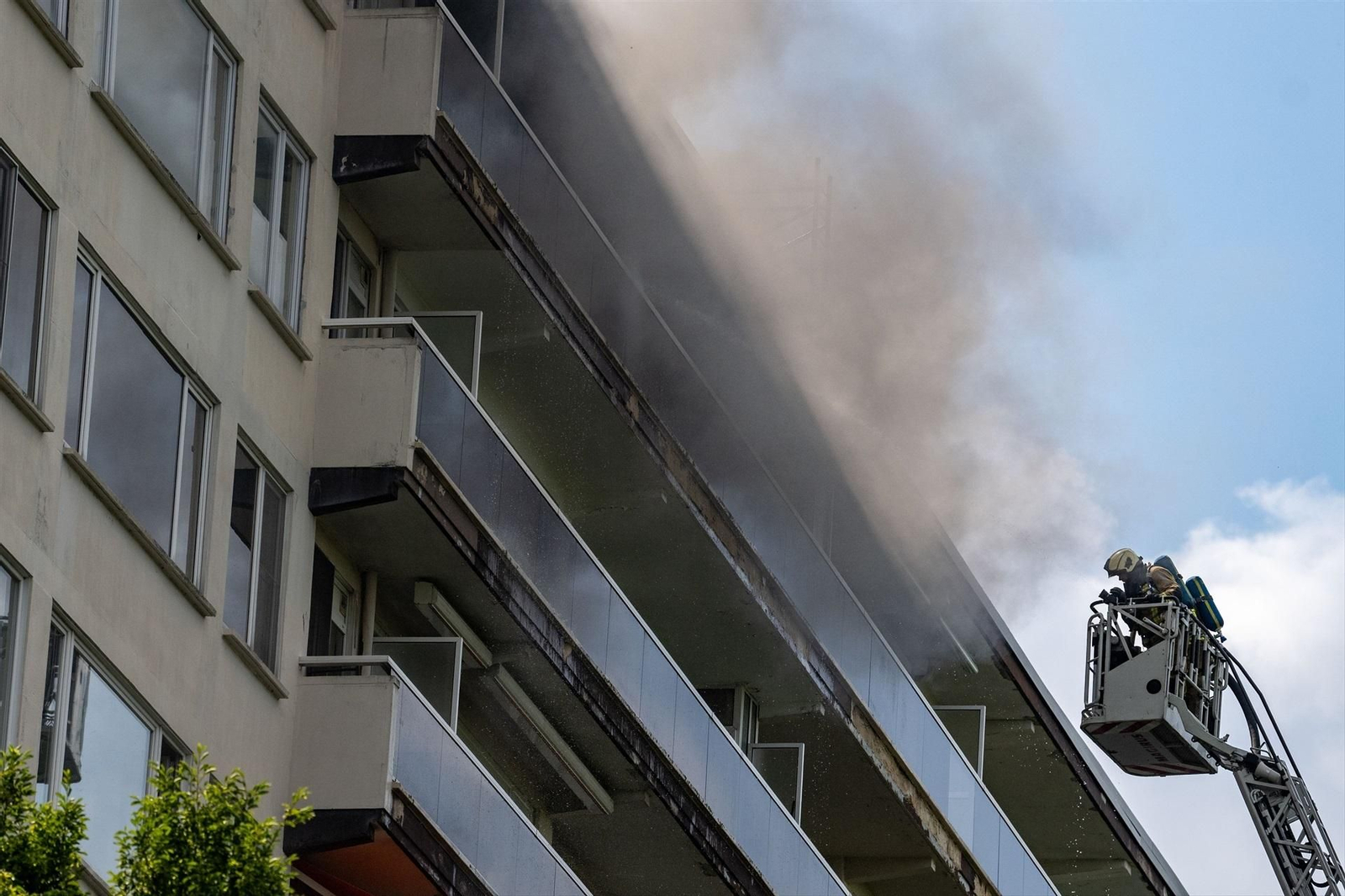 Un bombero sube en una cesta al edificio en llamas