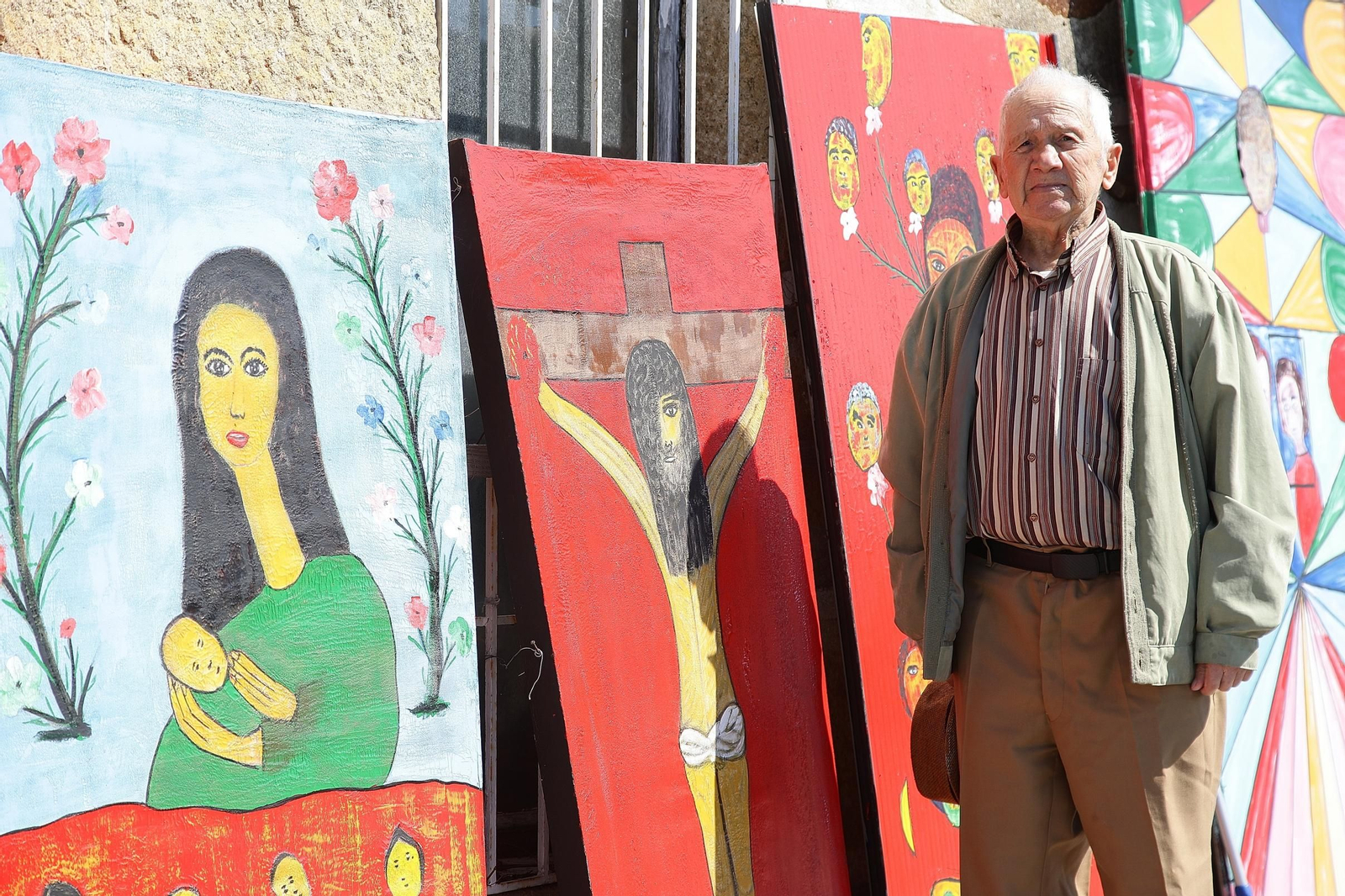 El pintor en las inmediaciones de su casa, con obras que recuerdan la Semana Santa y la primavera.