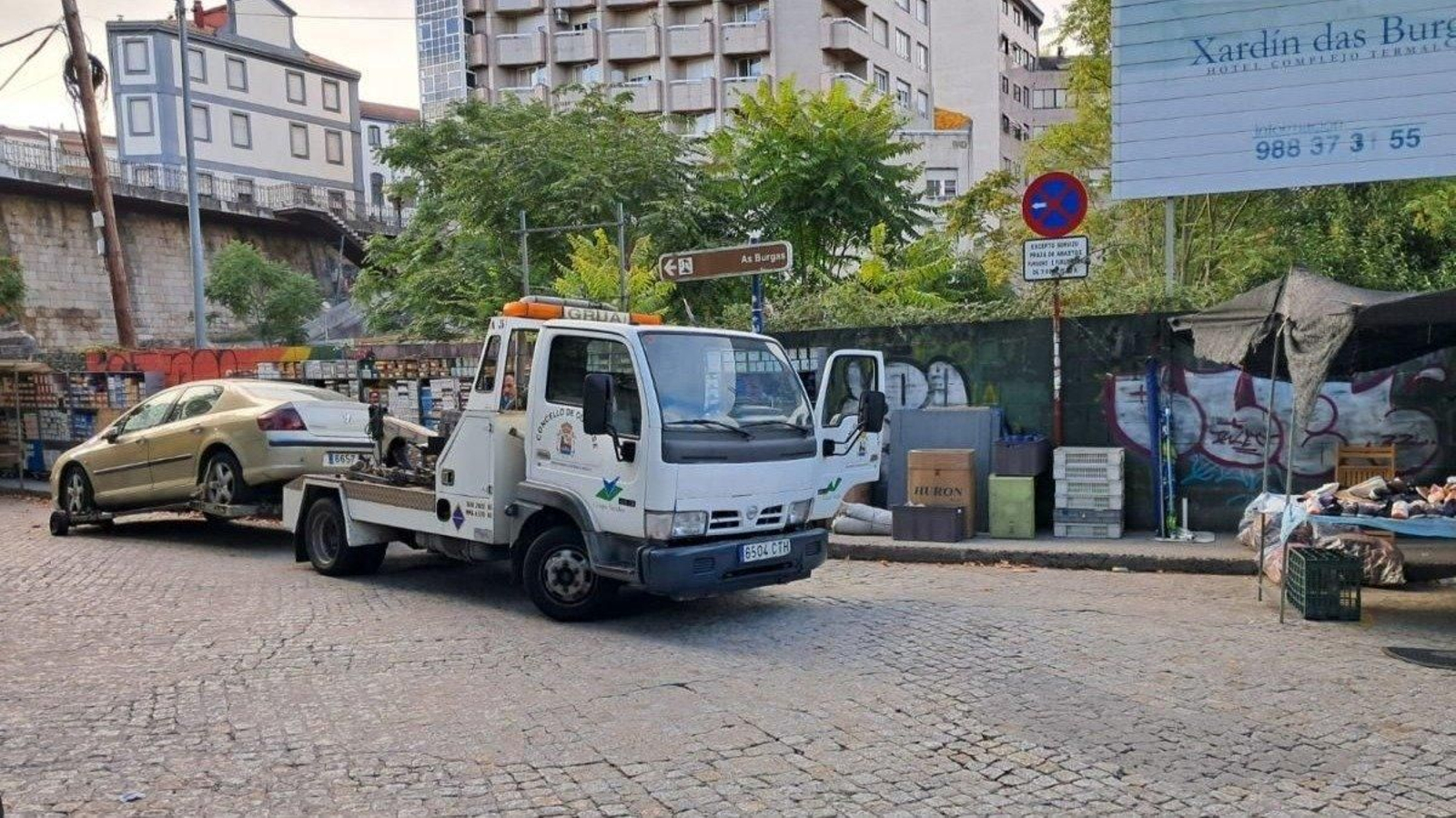 La grúa se lleva uno de los coches mal aparcados en el entorno de la Plaza de Abastos de Ourense.