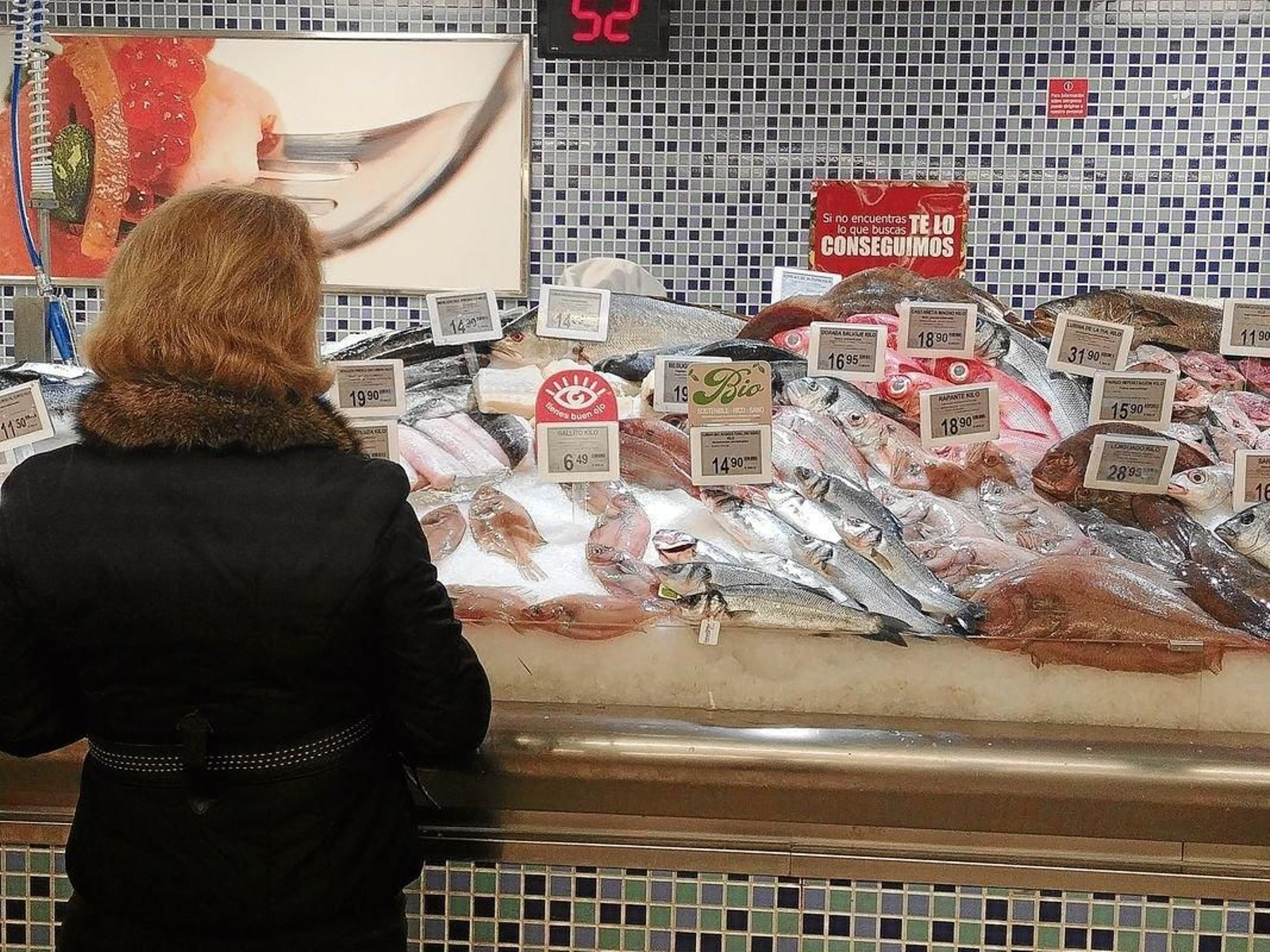 Maricarmen consulta los mejores precios en la pescadería.