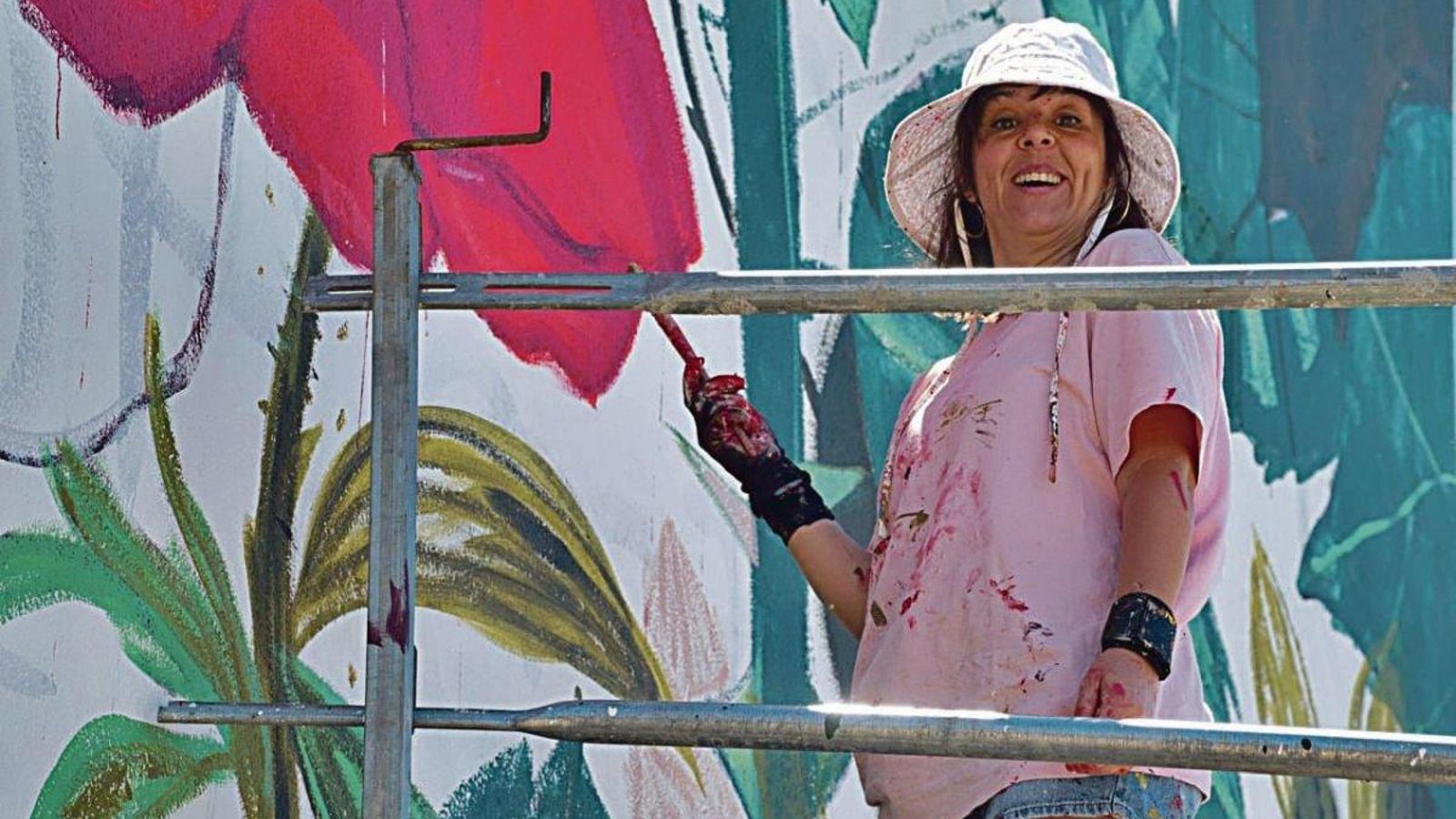La artista sevillana terminando su mural en el pabellón municipal de Teis.