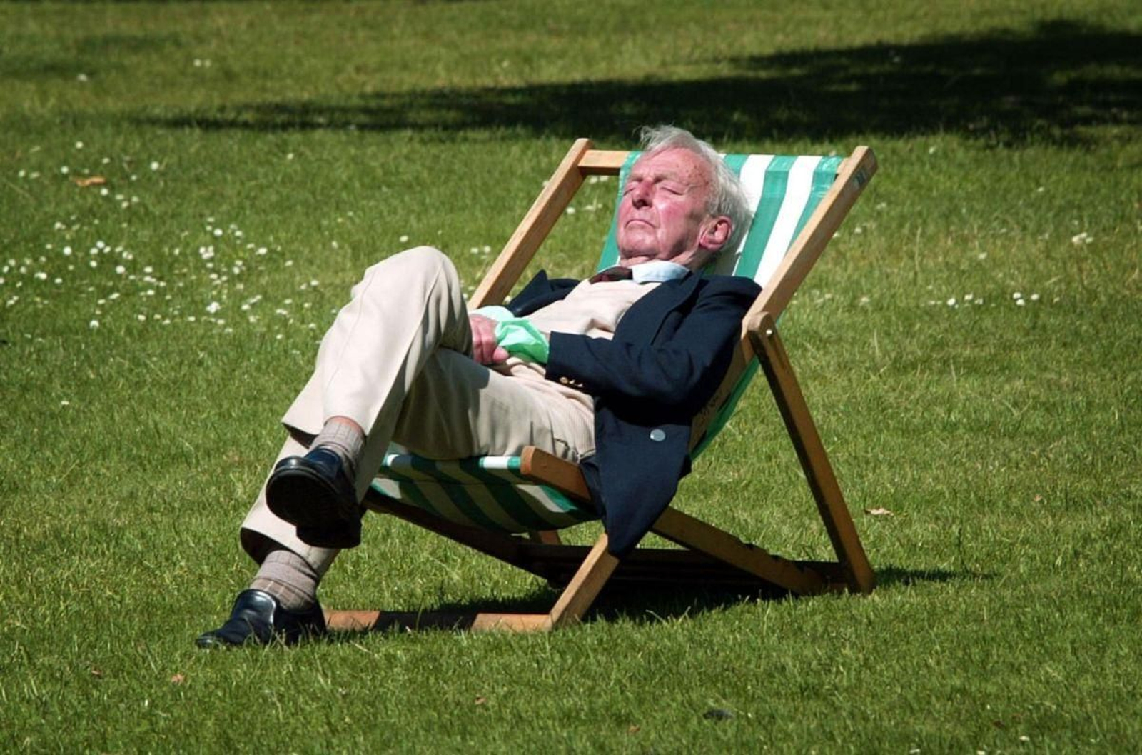 Un hombre duerme la siesta en el jardín.