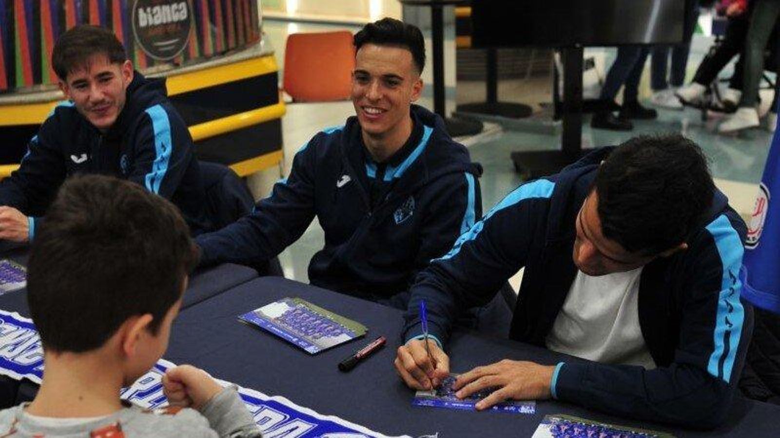 Los jugadores del Ourense CF, en la firma a un joven seguidor.