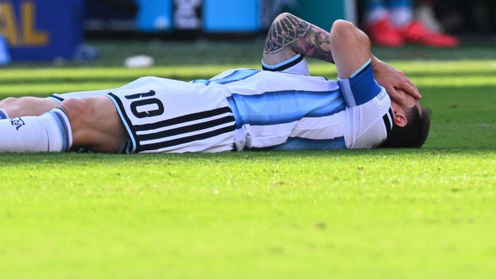 Leo Messi se queja sobre el césped de un golpe en la cara de Laporte.