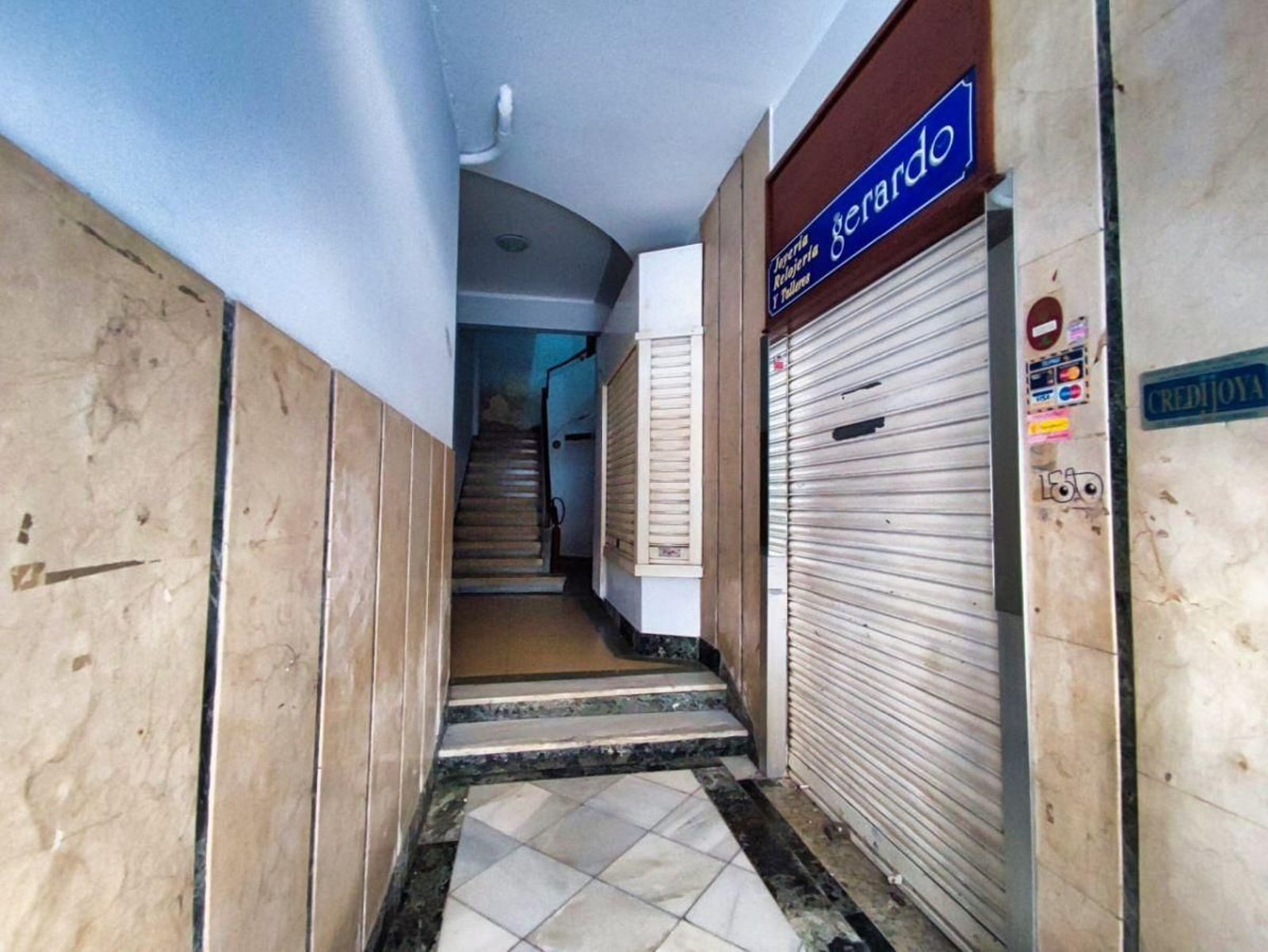 Interior de uno de los edificios de Alfonso X que están okupados y con los locales cerrados.