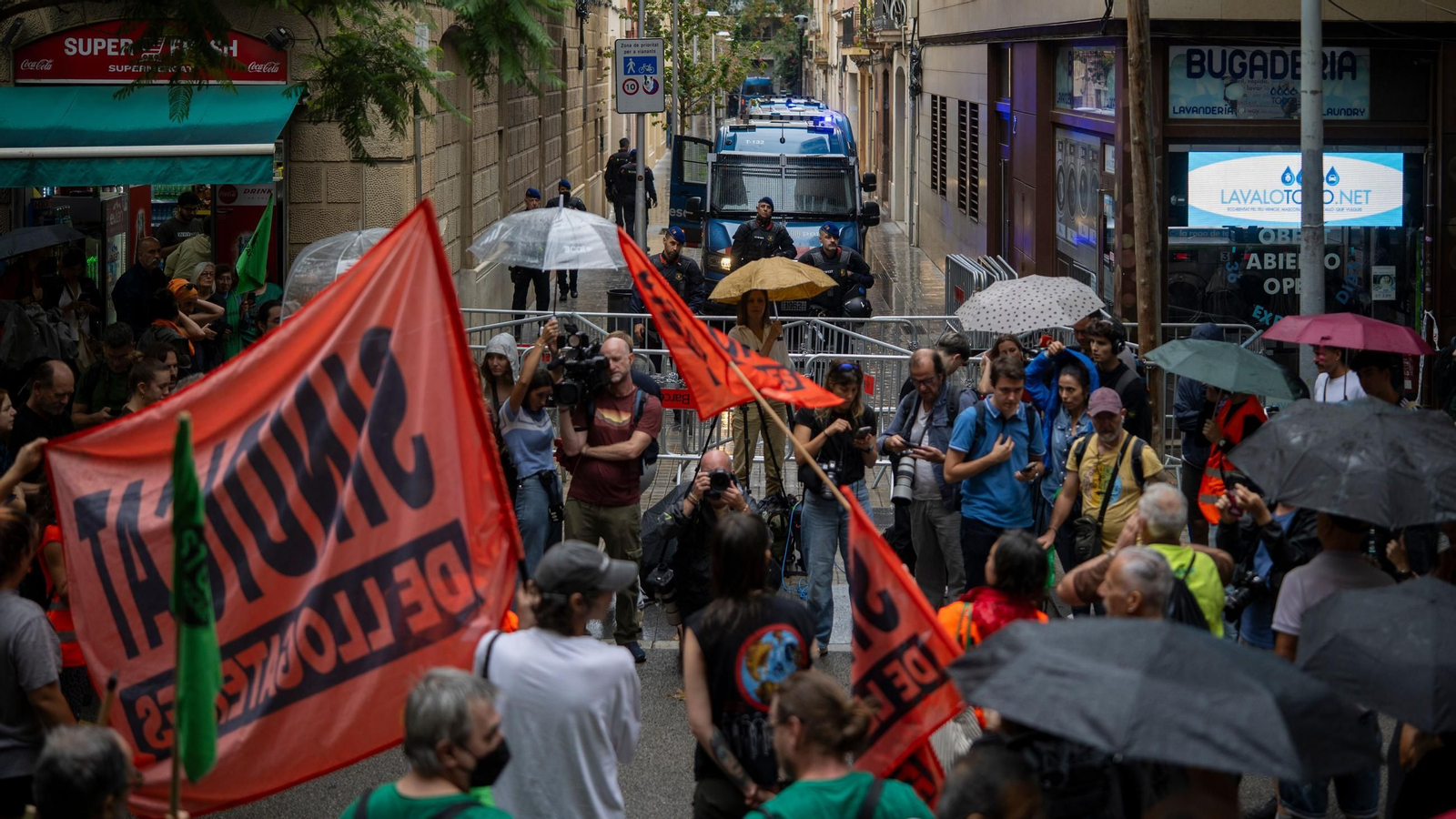 Manifestantes concentrados ante el cordón policial desplegado en los aledaños del Congreso de los Diputados durante la protesta en defensa del derecho a la vivienda