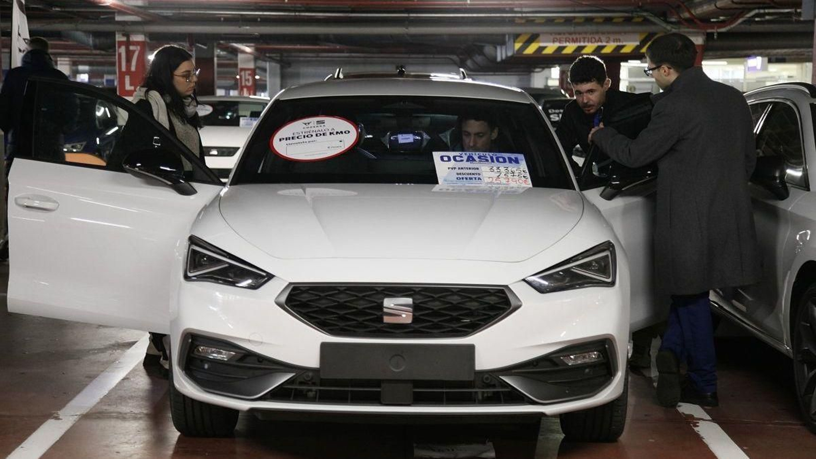 Visitantes a una feira de automóviles comprueban un modelo.