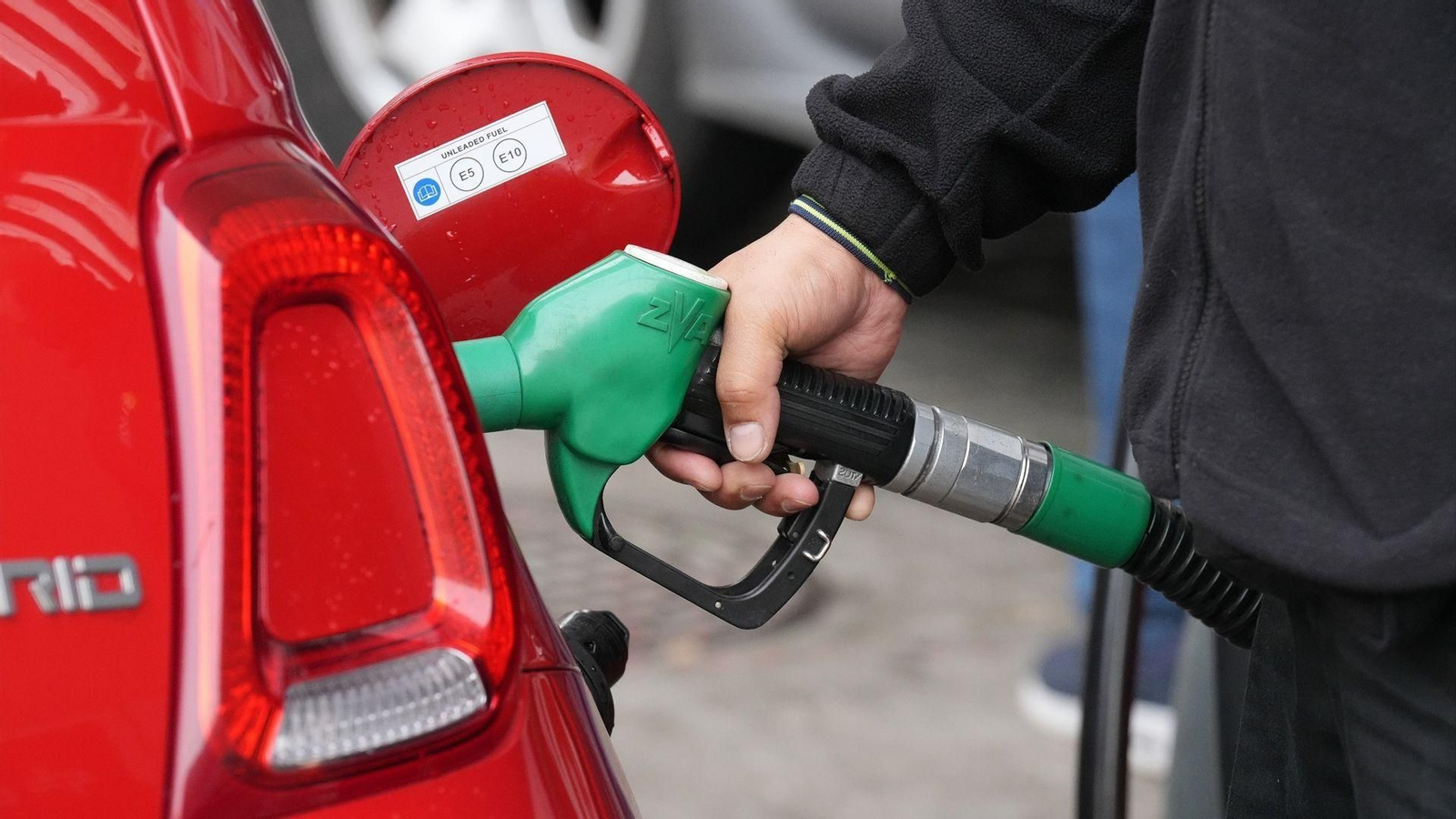 Una persona echa combustible a un vehículo.