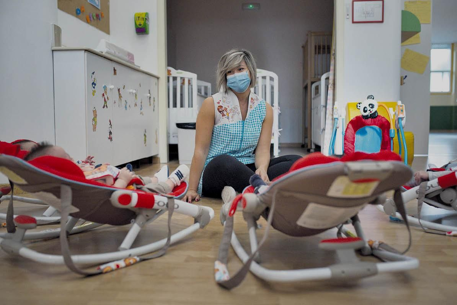 Una cuidadora atiende a niños en una guardería.