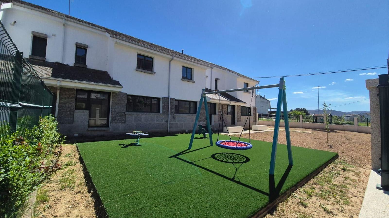 Espacio exterior del punto de encuentro familiar de Verín, con una zona de juegos infantiles.